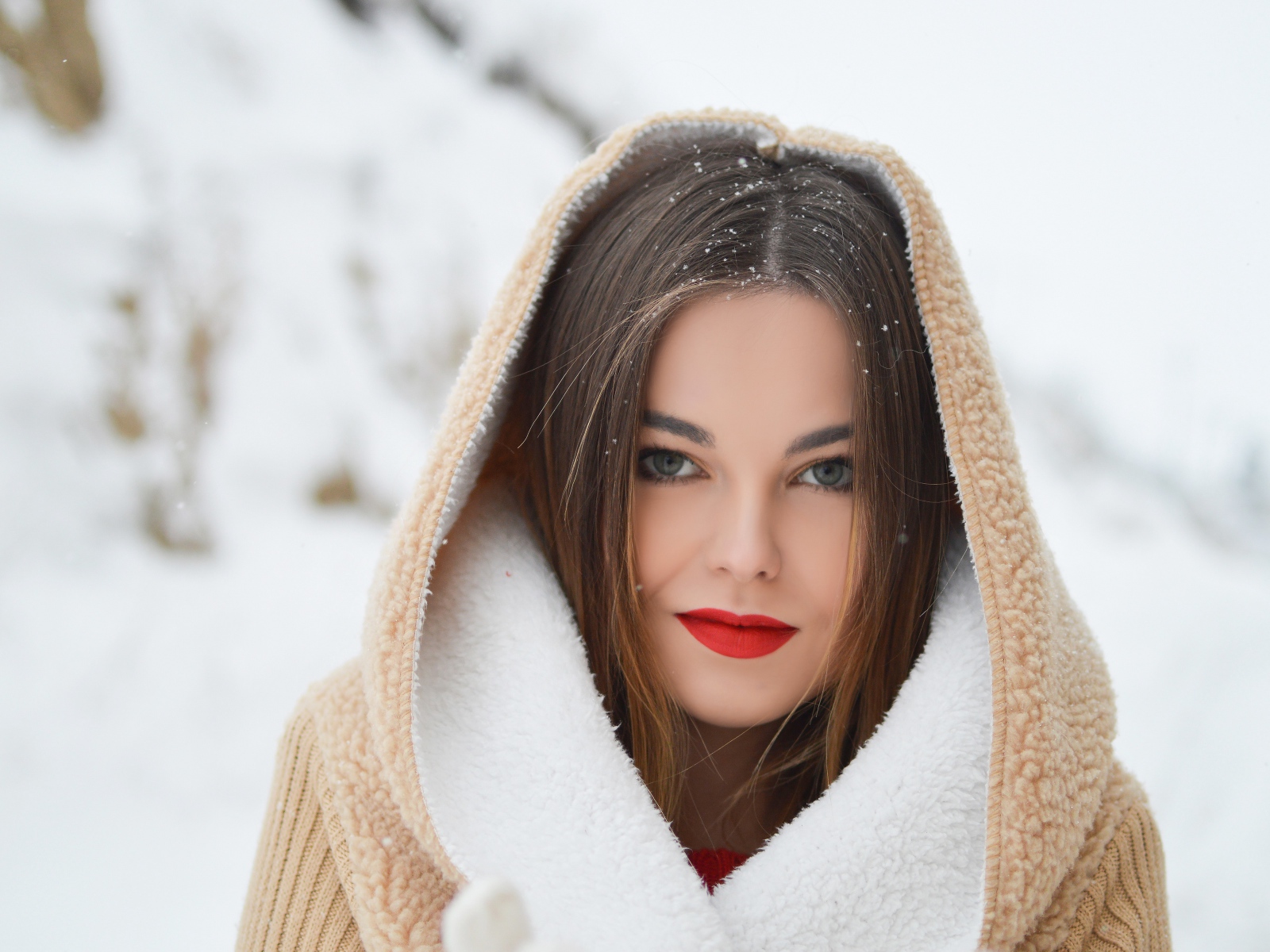 Красивая девушка с красными губами в теплой куртке зимой