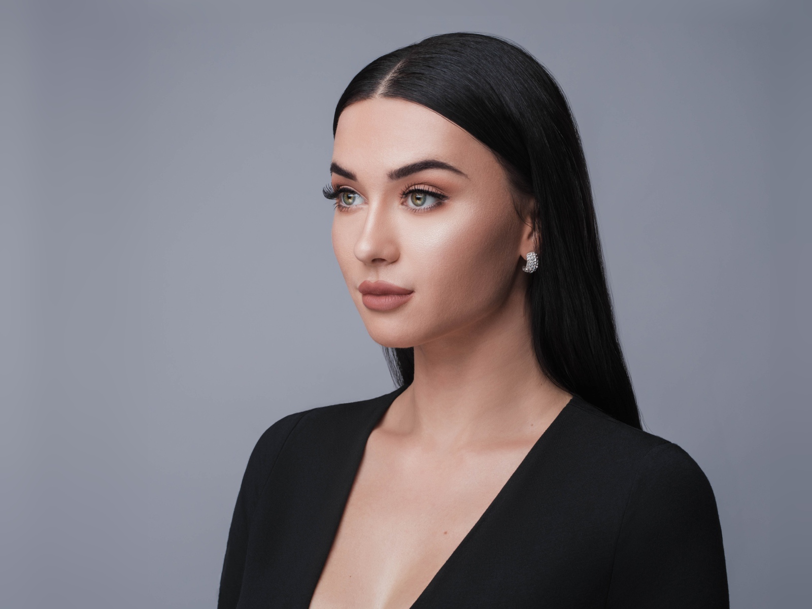 Красивая длинноволосая брюнетка в черном фото на сером фоне