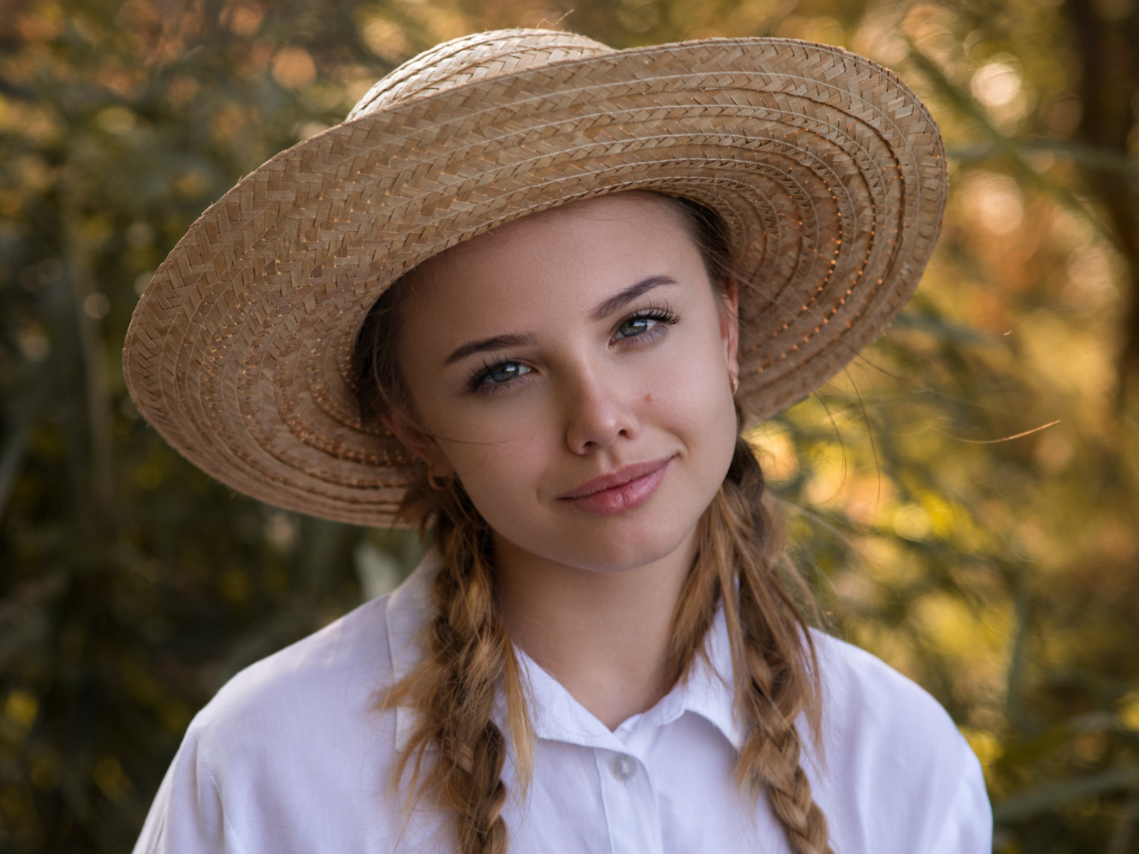 Красивая молодая девушка в соломенной шляпе