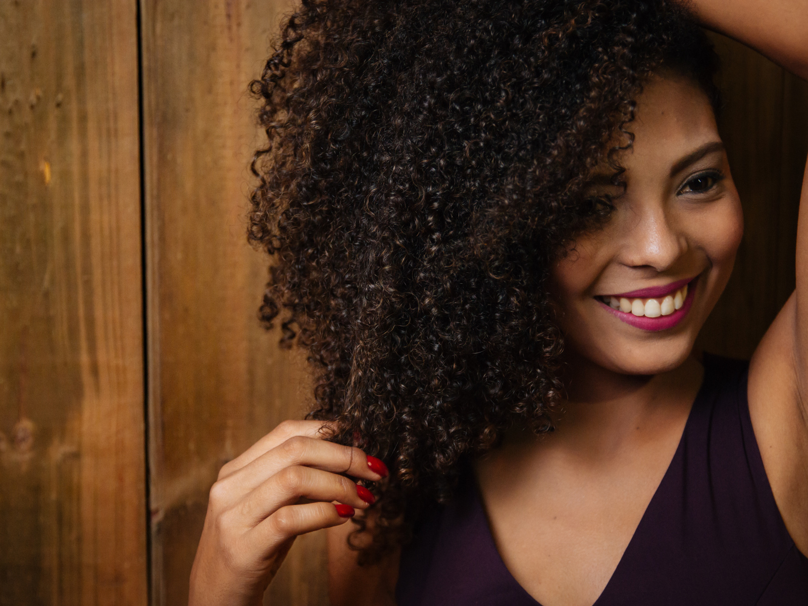 Кучерявая темнокожая девушка с красивой улыбкой 