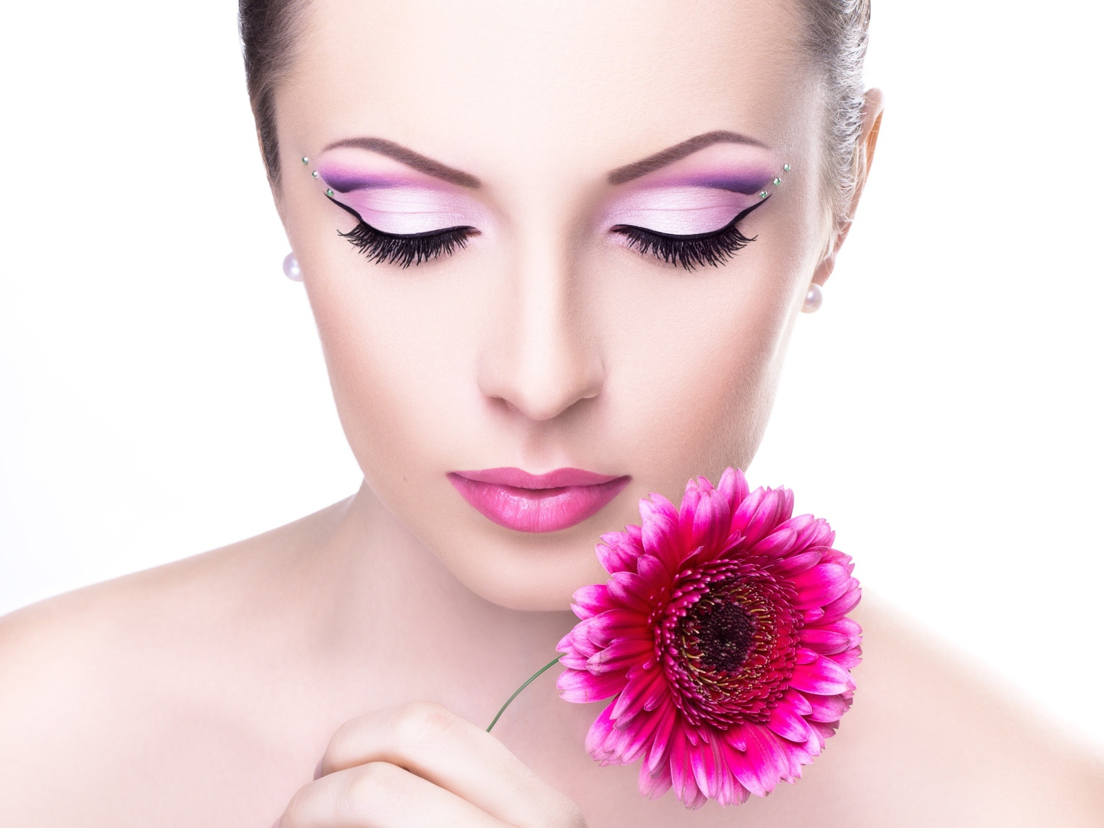 Нежная девушка с розовым цветком герберы на белом фоне