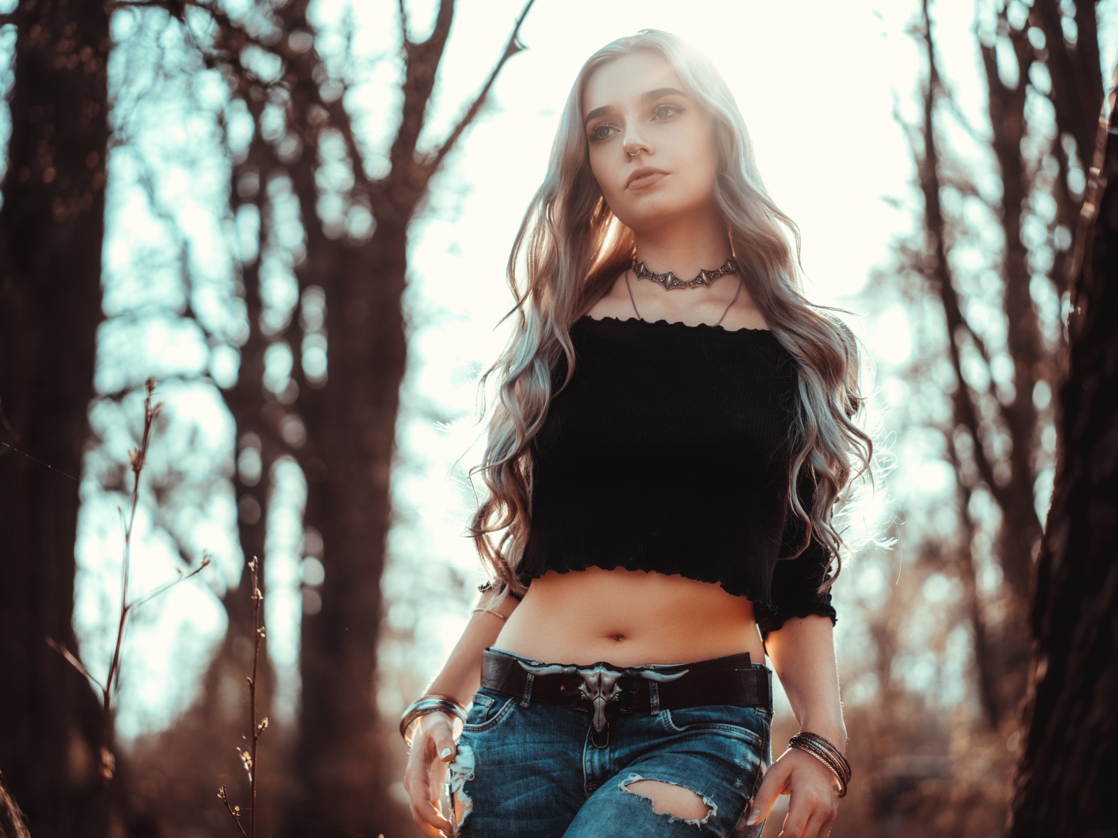 Молодая девушка в рваных джинсах с пирсингом в носу