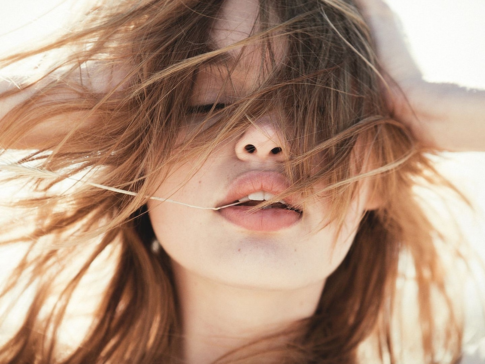Молодая девушка с распущенными волосами на ветру