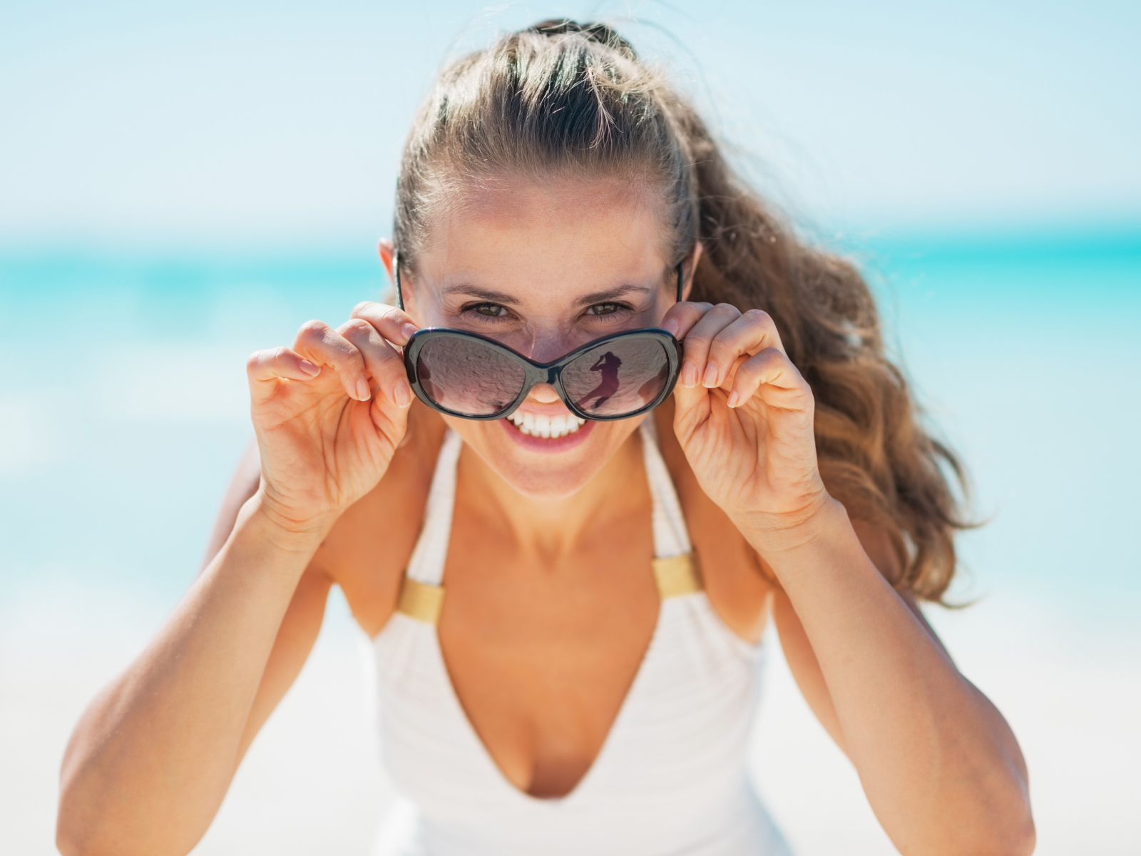 Молодая улыбающаяся девушка в солнечных очках 