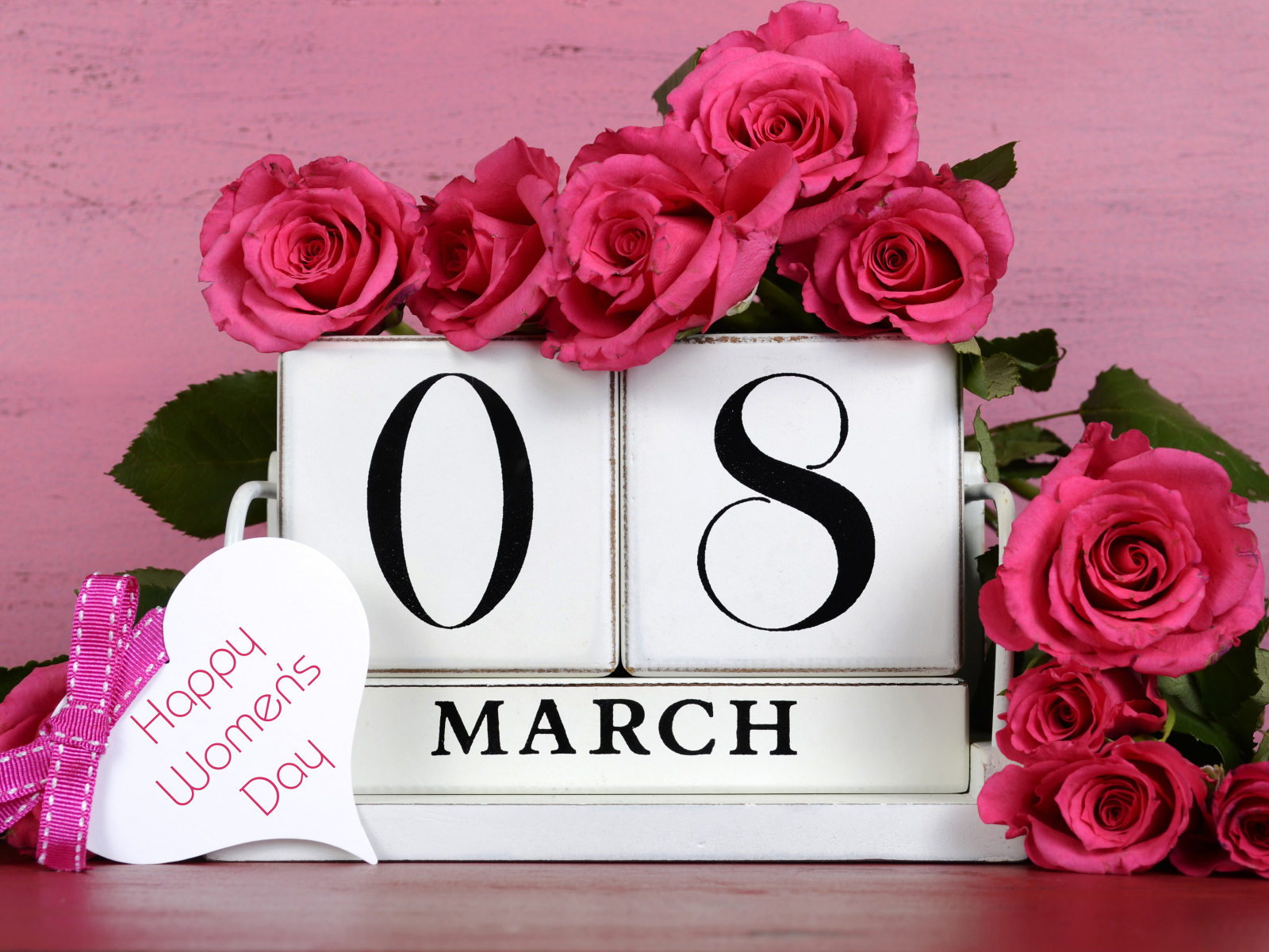 Красные розы на розовом фоне на Международный женский день