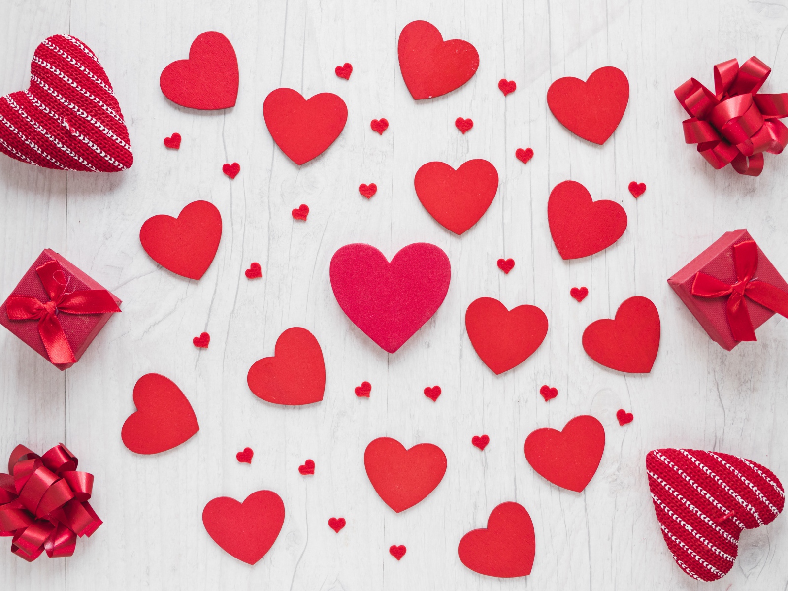 Много красных сердечек на столе с подарками 