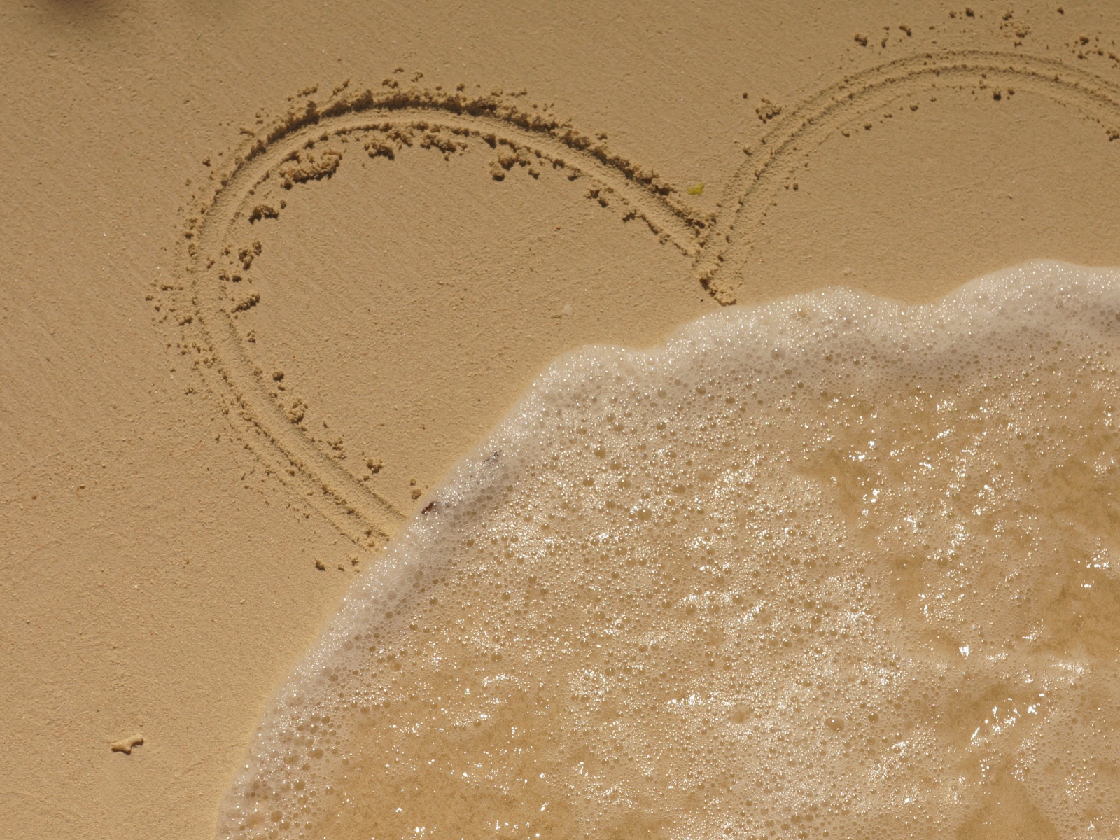 Сердце на песке смывает волной