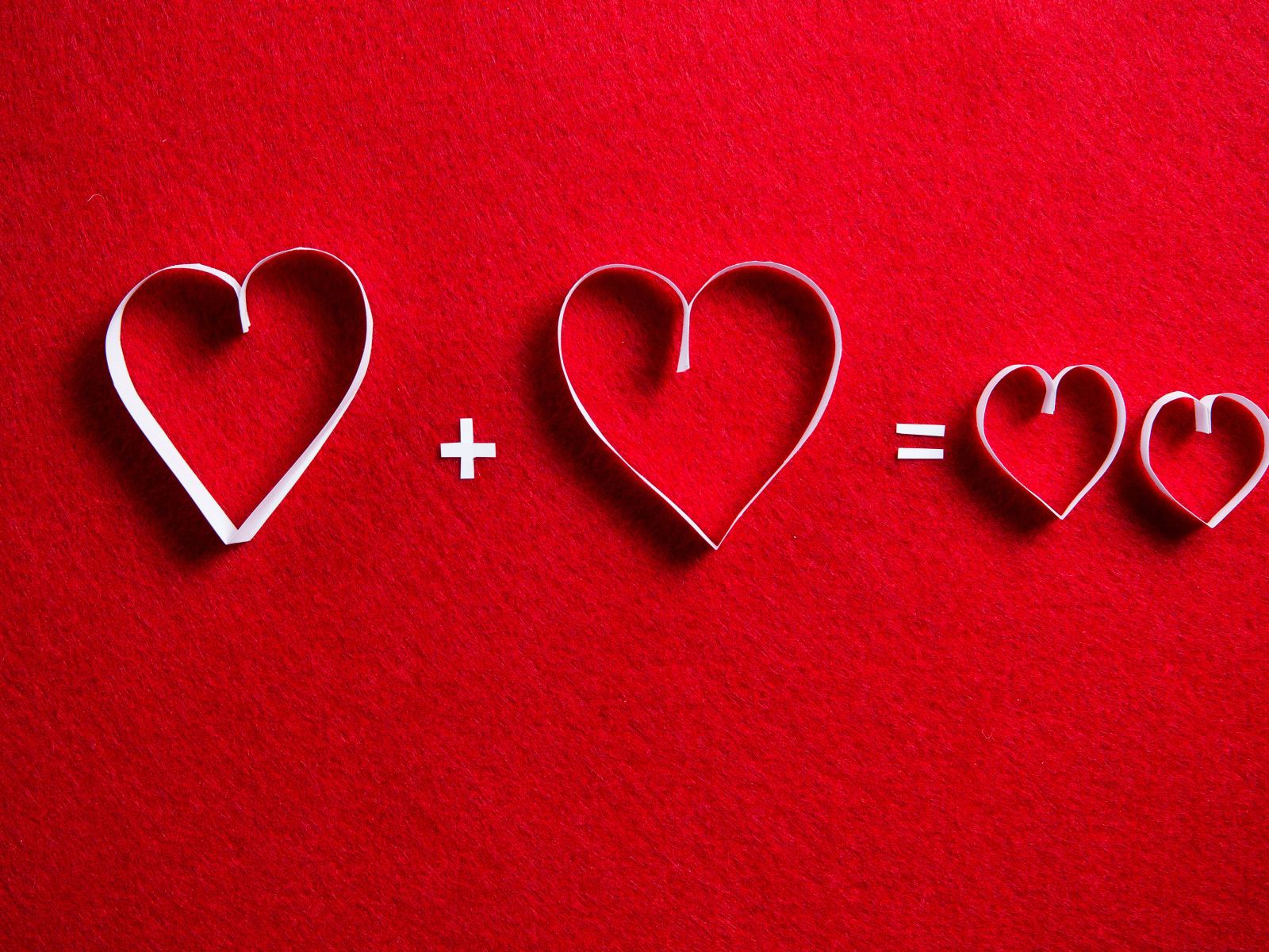 Белые бумажные сердечки на красном фоне