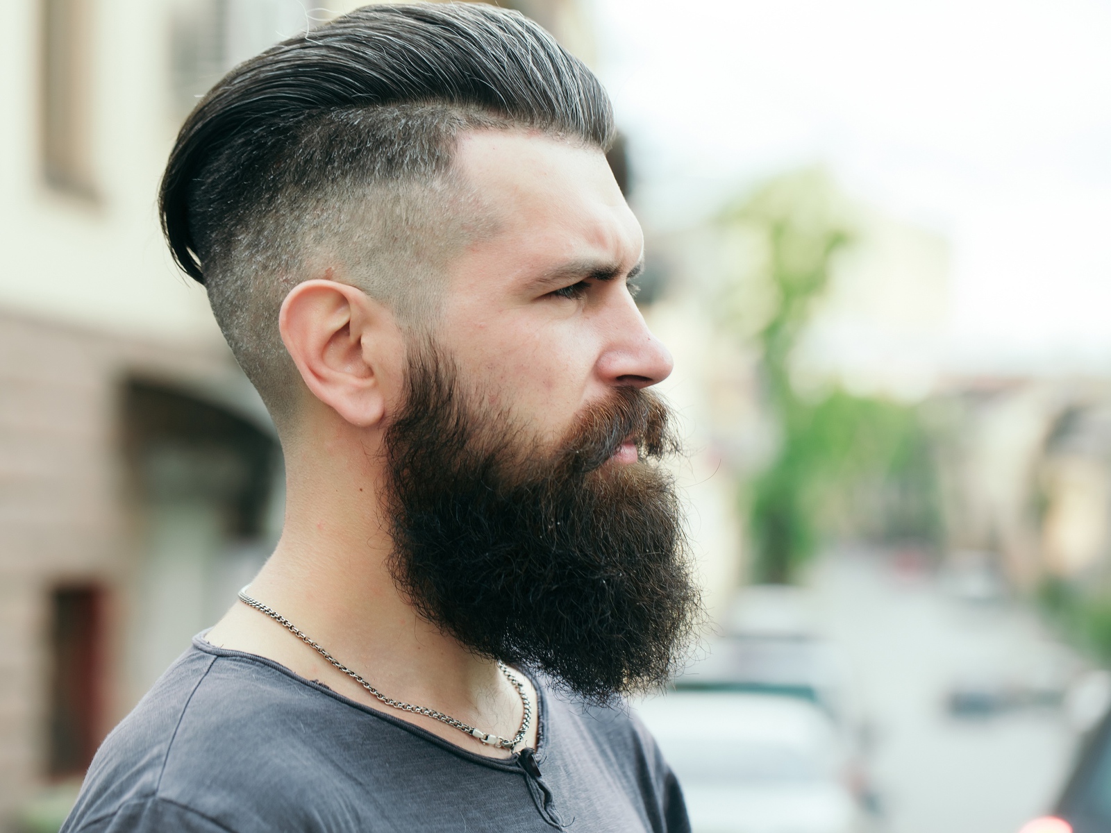 Стильный мужчина с бородой и прической на голове 