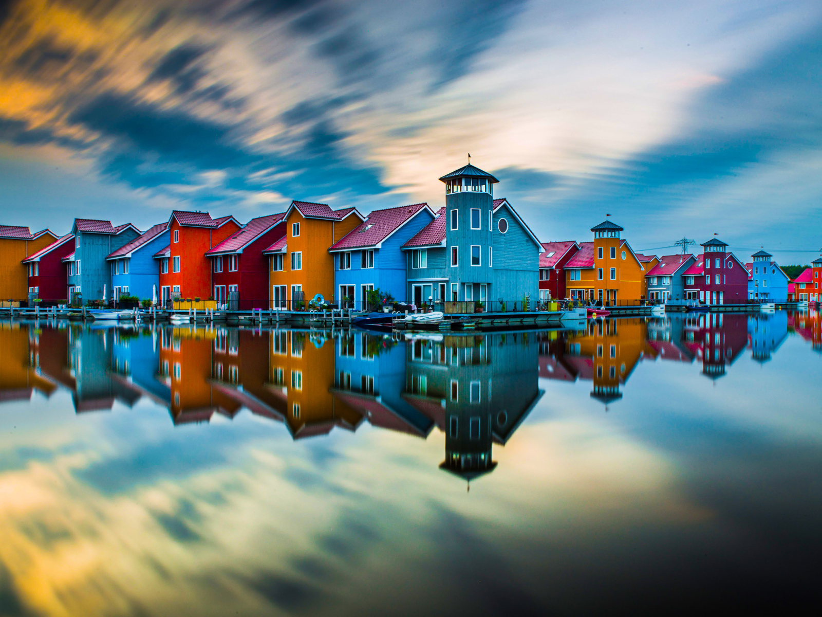 Красивые разноцветные дома отражаются в воде под красивым небом