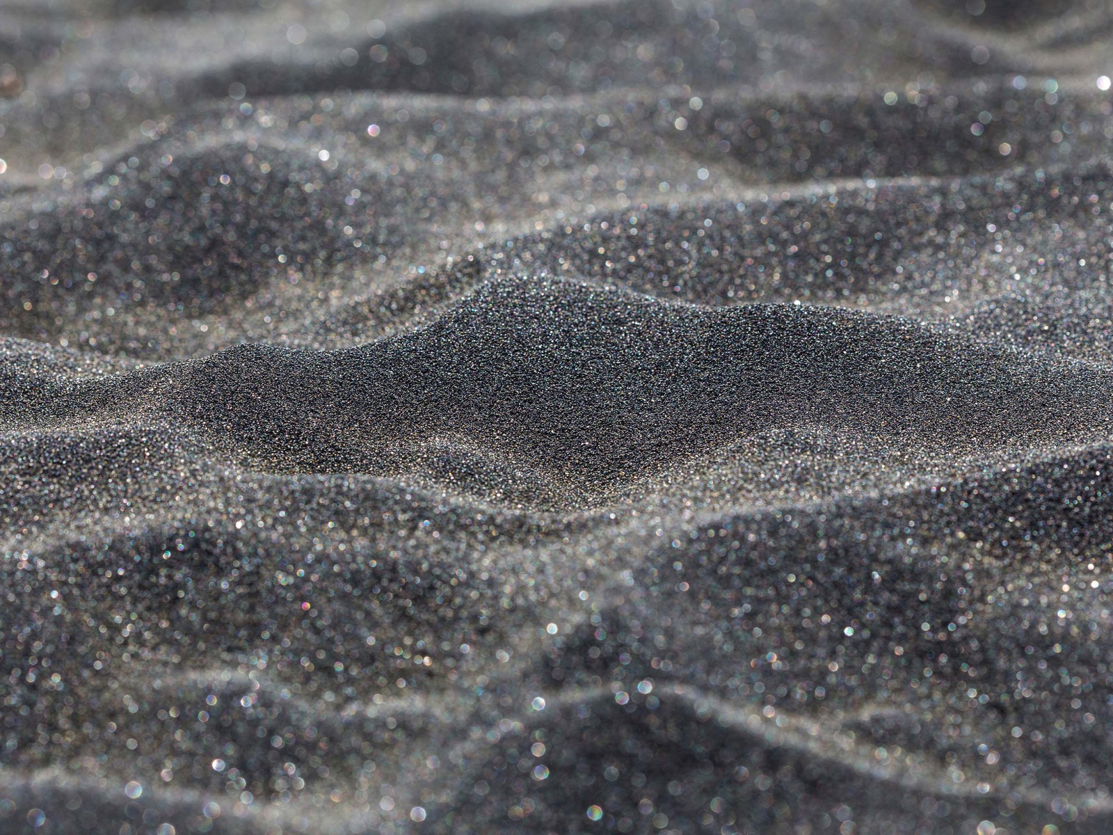 Блестящий черный песок крупным планом