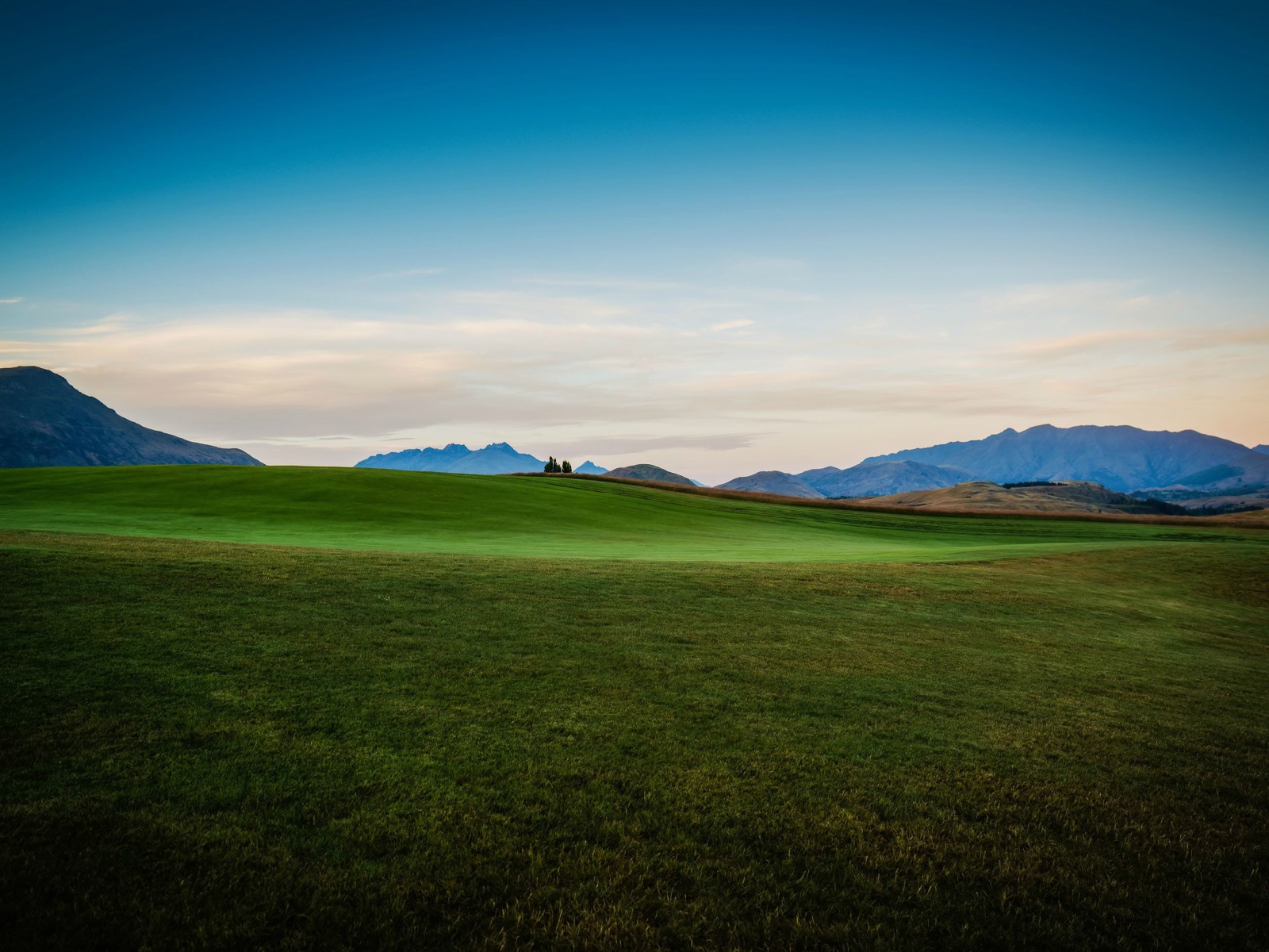 Зеленый луг на фоне красивого неба