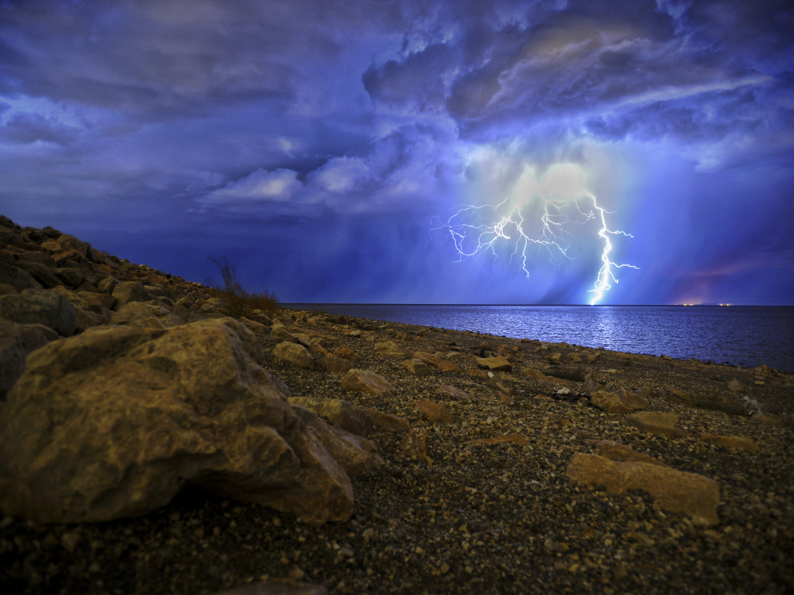 Молния в море пронзает грозовое небо 