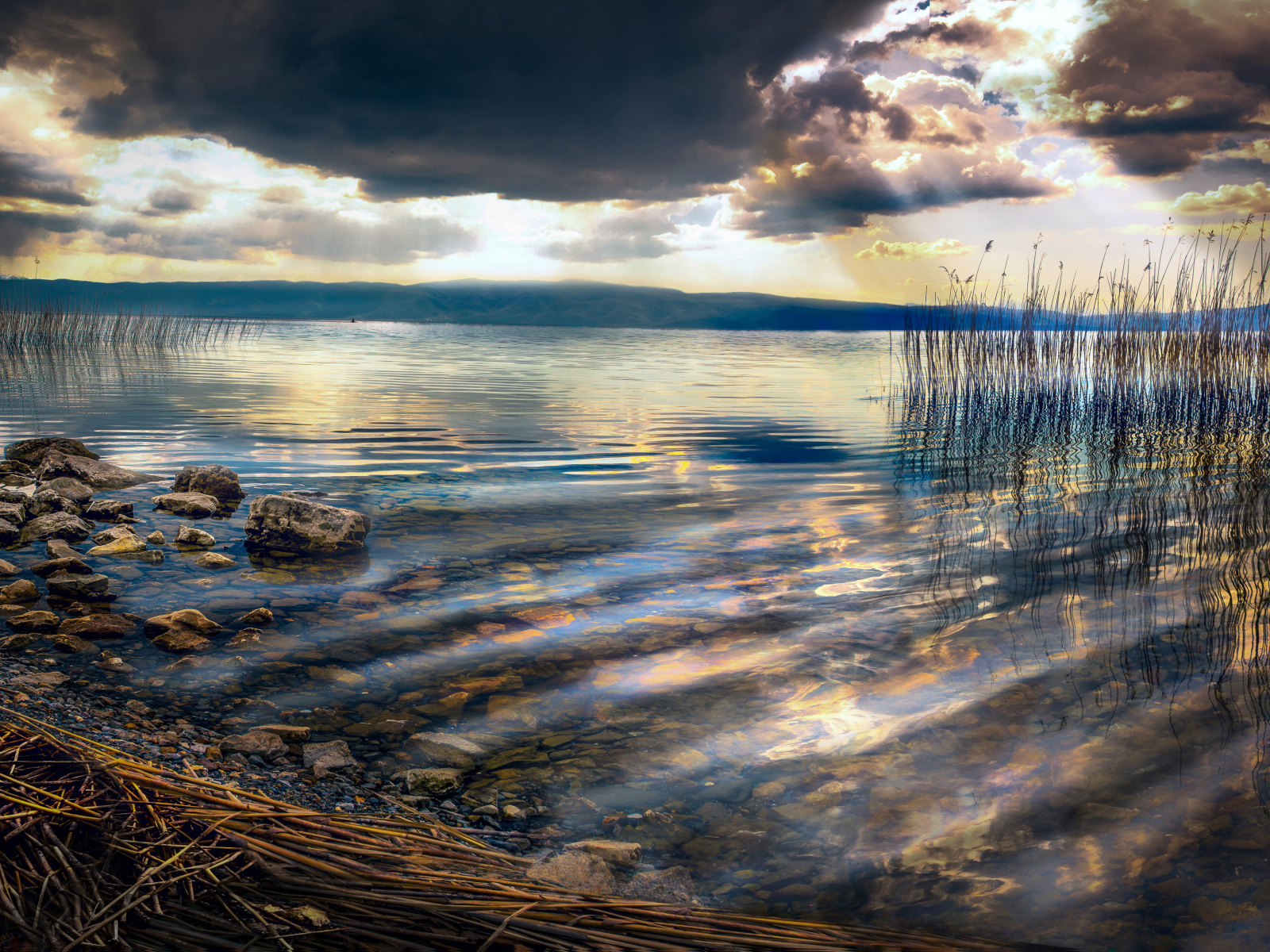 Камни в озере под красивым небом на закате