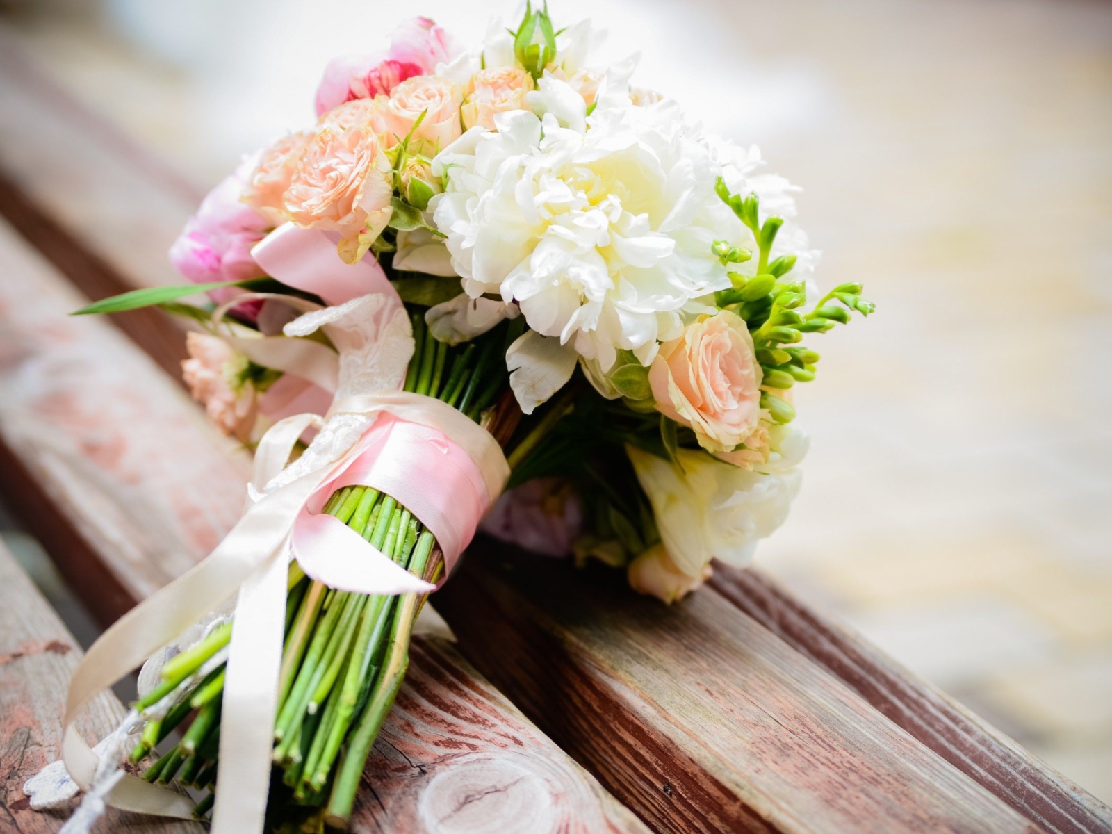 Красивый свадебный букет лежит на деревянной лавке