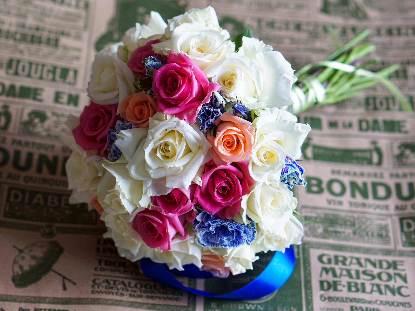 Красивый свадебный букет из роз лежит на газете