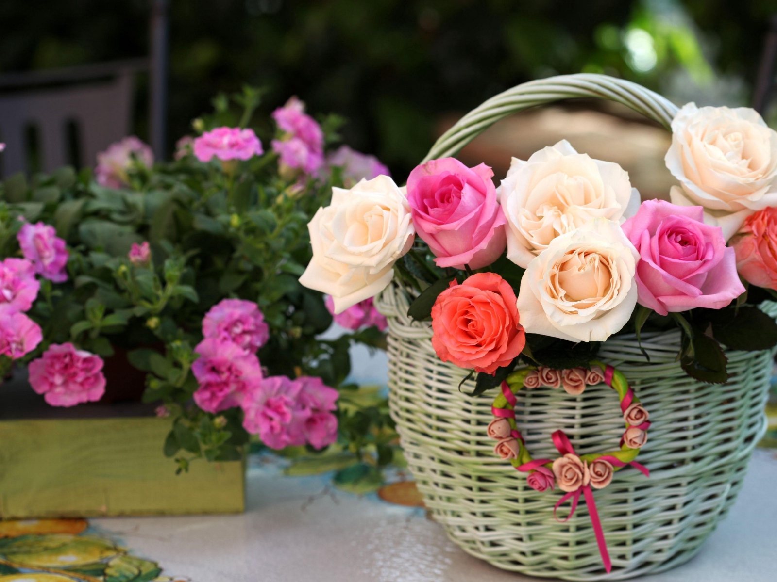 Букет нежных роз в корзине на столе с цветами