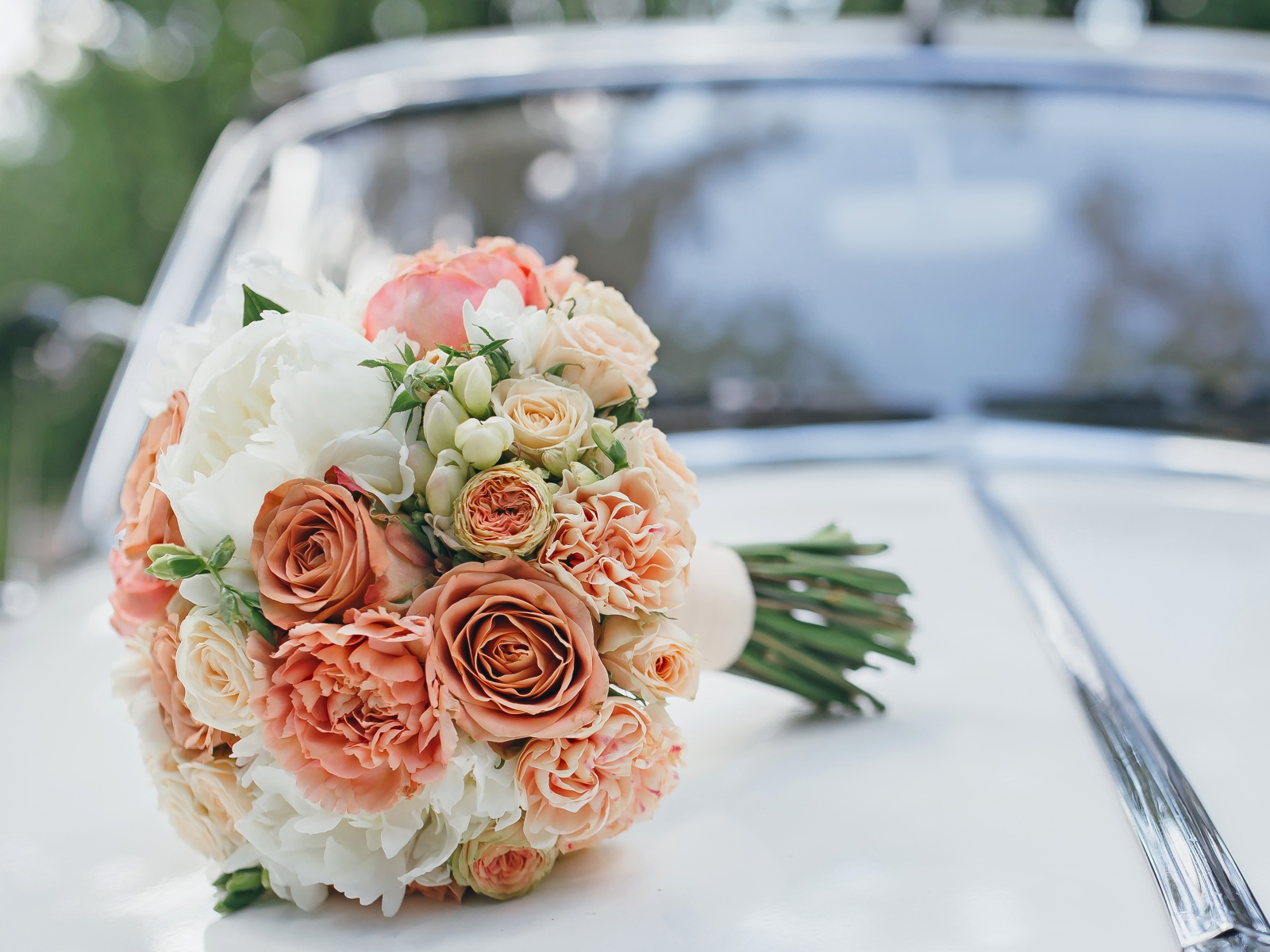 Свадебный букет роз лежит на машине