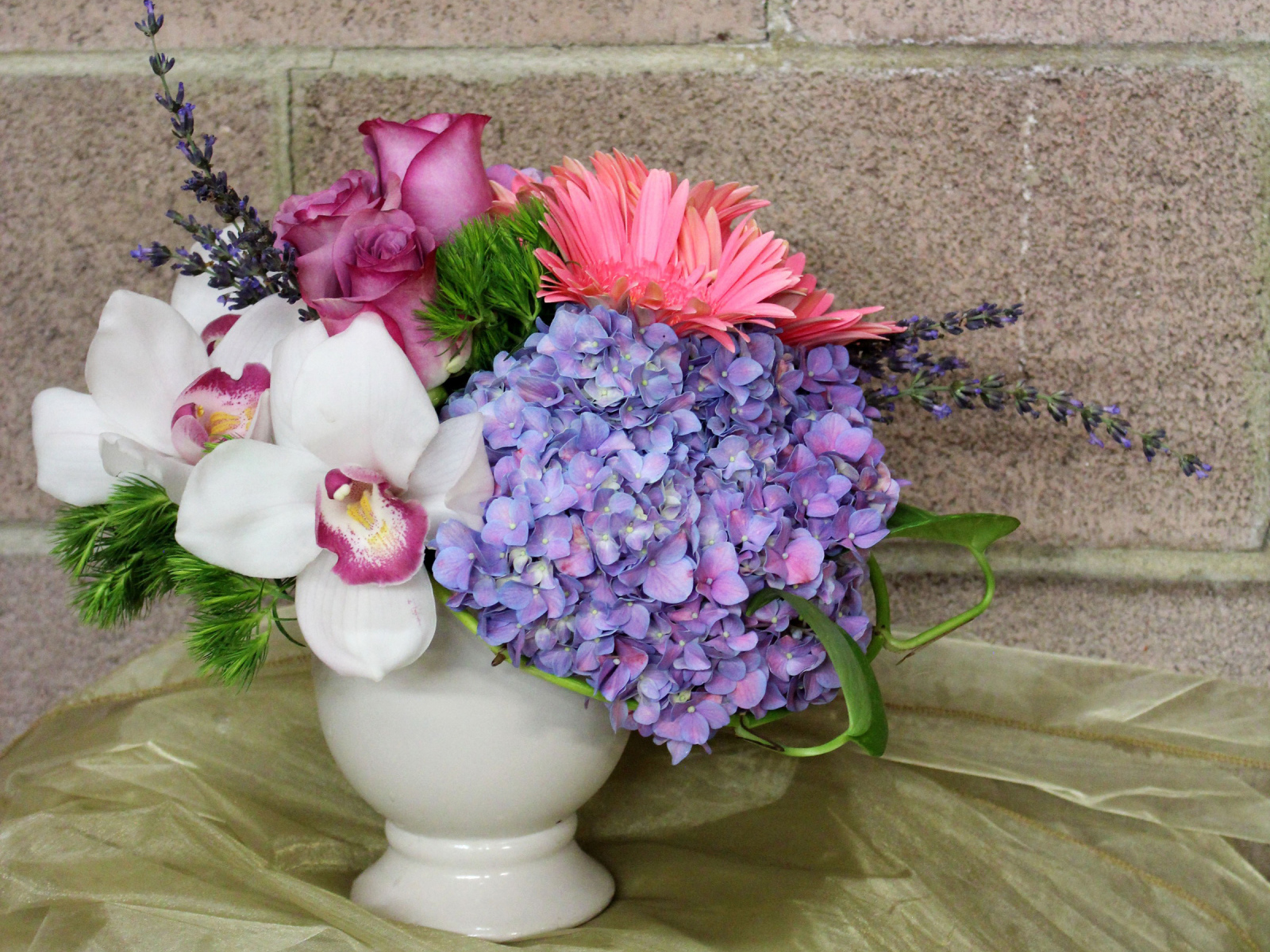 Красивый букет в белой вазе на фоне стены 