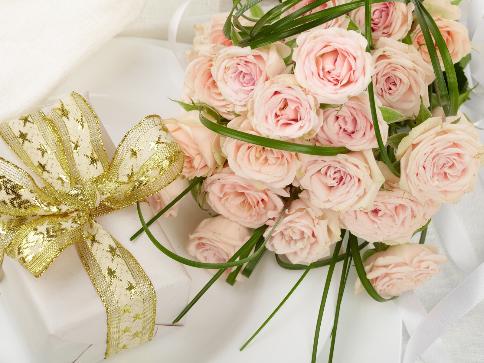 Букет розовых роз и подарок с красивым бантом