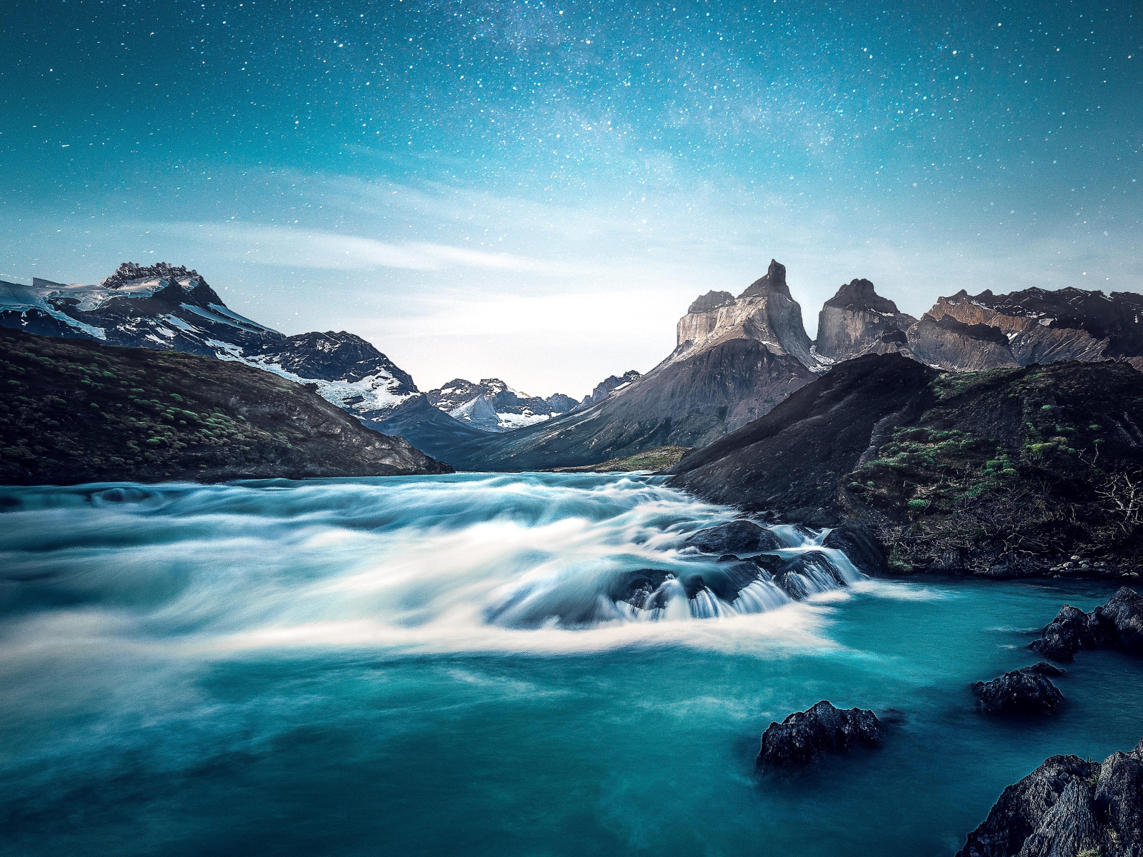 Быстрая вода к реке у гор на фоне голубого неба 