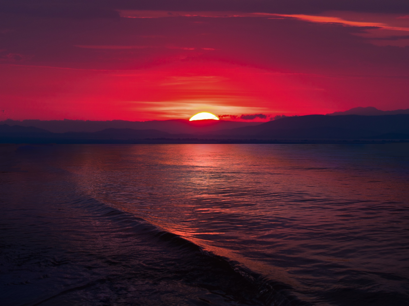 Закат красного солнца на морском горизонте 