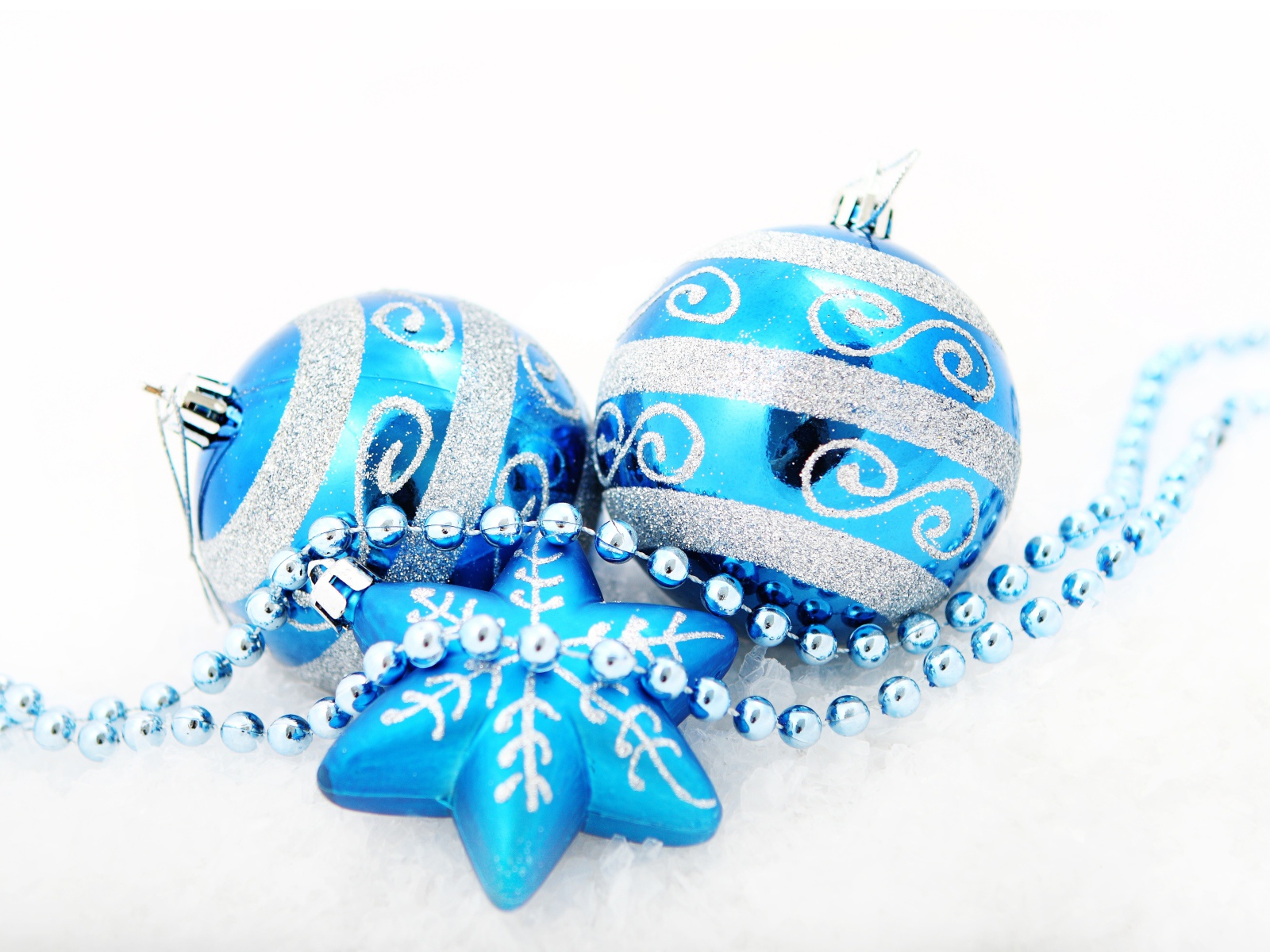 Красивые голубые елочные шарики со звездой и бусами на белом фоне