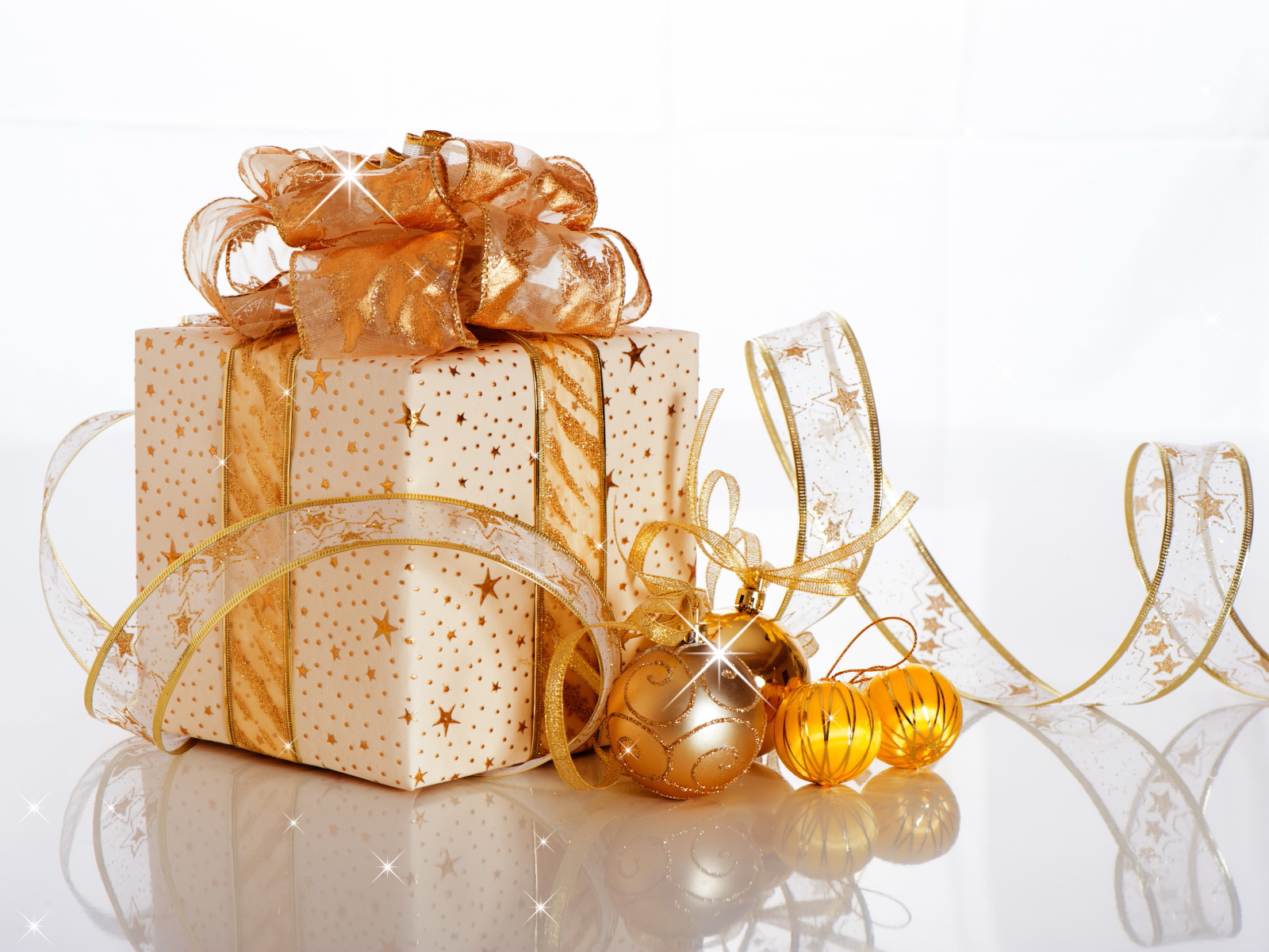 Красивый подарок с лентой и елочными шарами на белом фоне на Новый год 2019