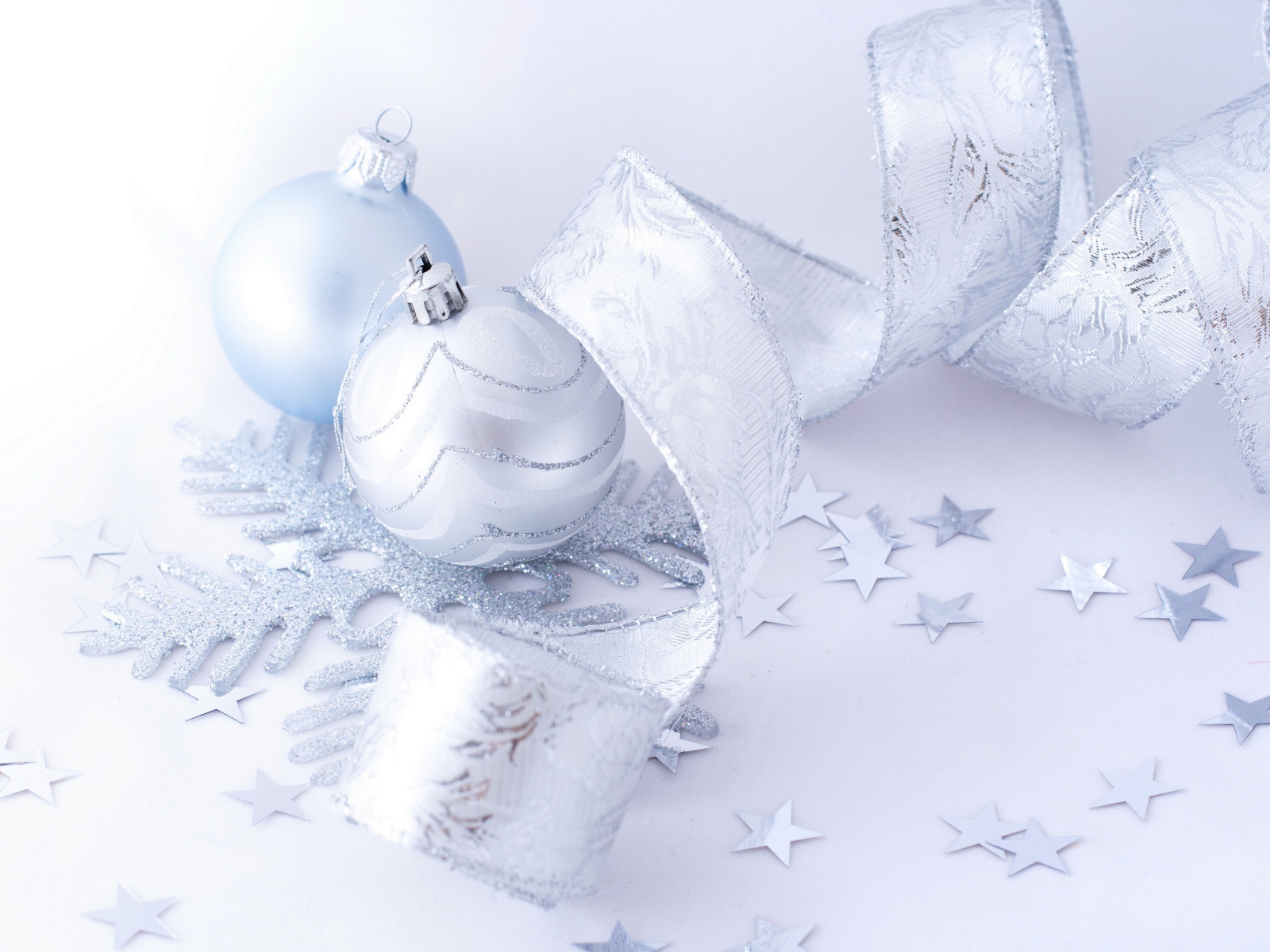 Красивые серые елочные шары с лентой на белом фоне