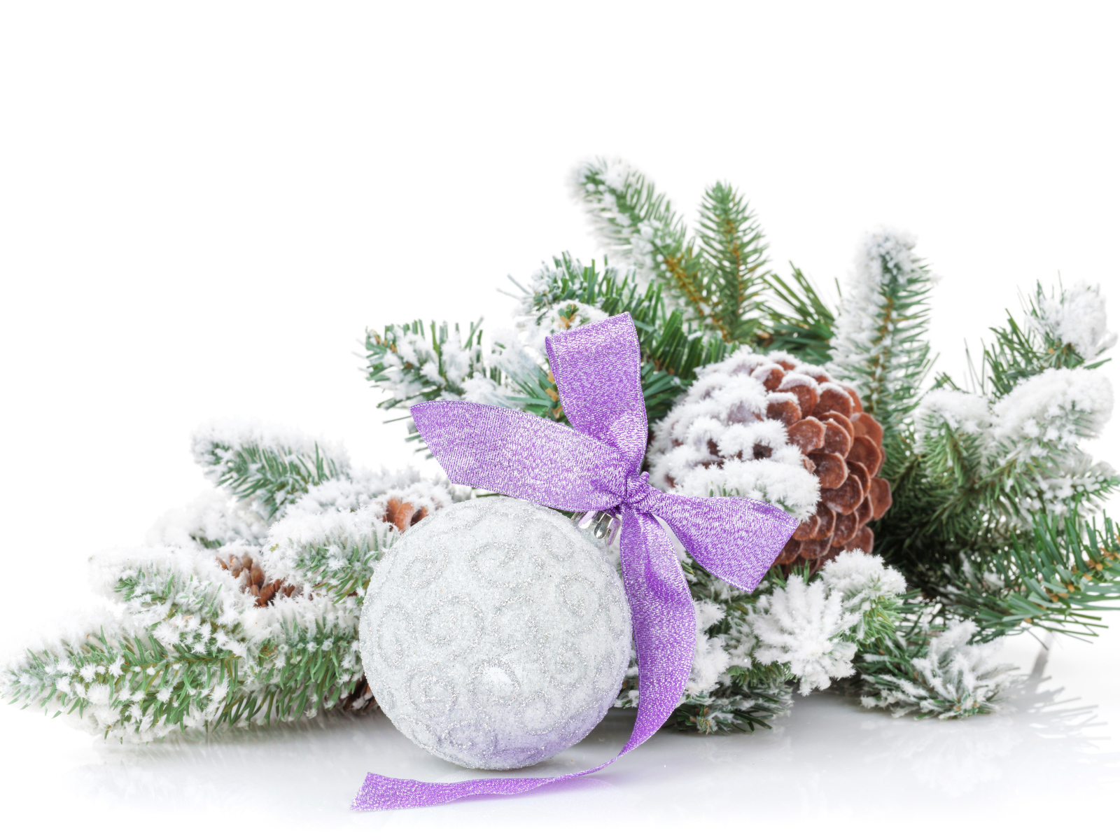 Серый елочный шар с бантом на зеленой ветке на Новый год 2019