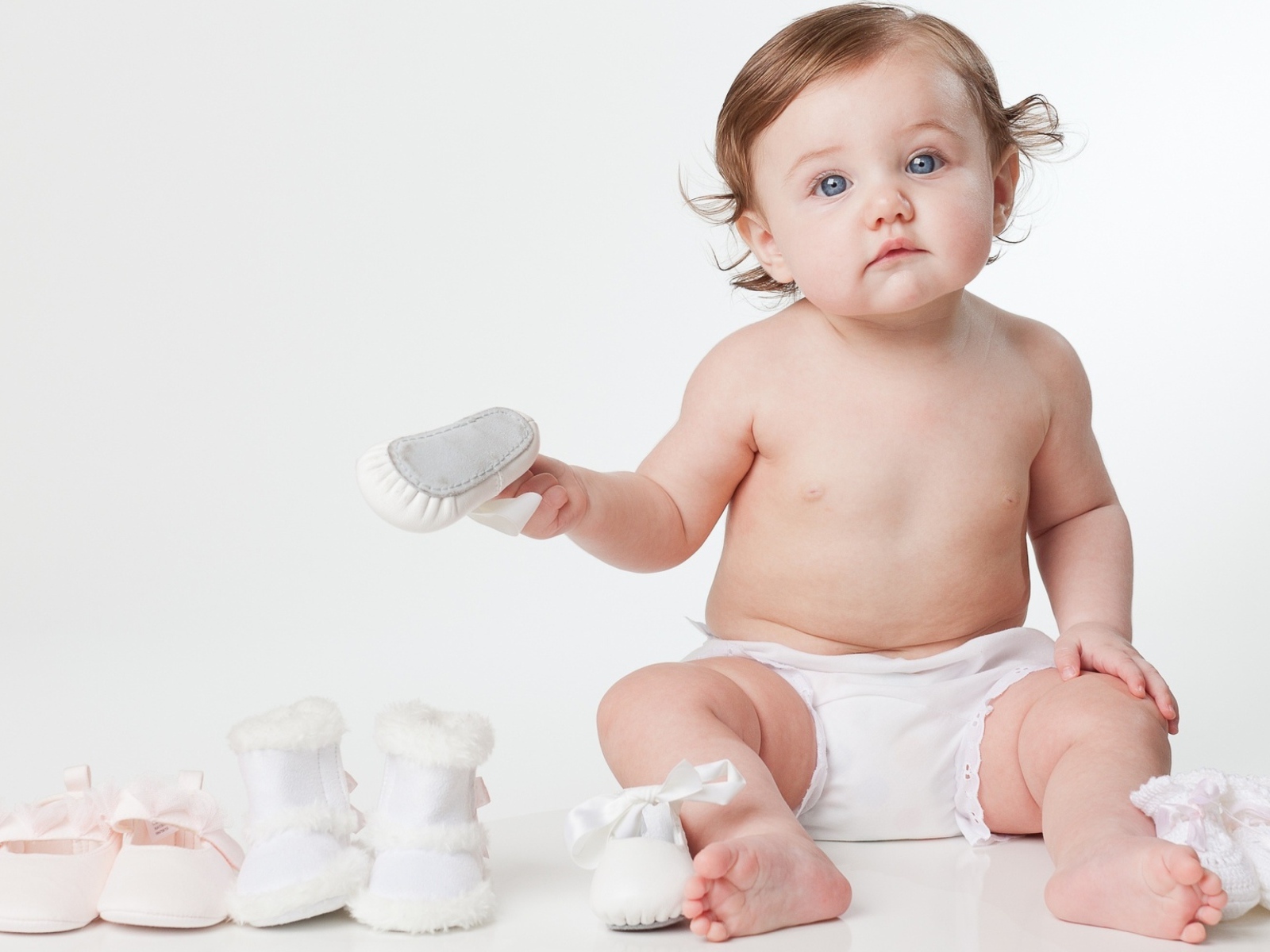Маленький грудной ребенок с детской обувью