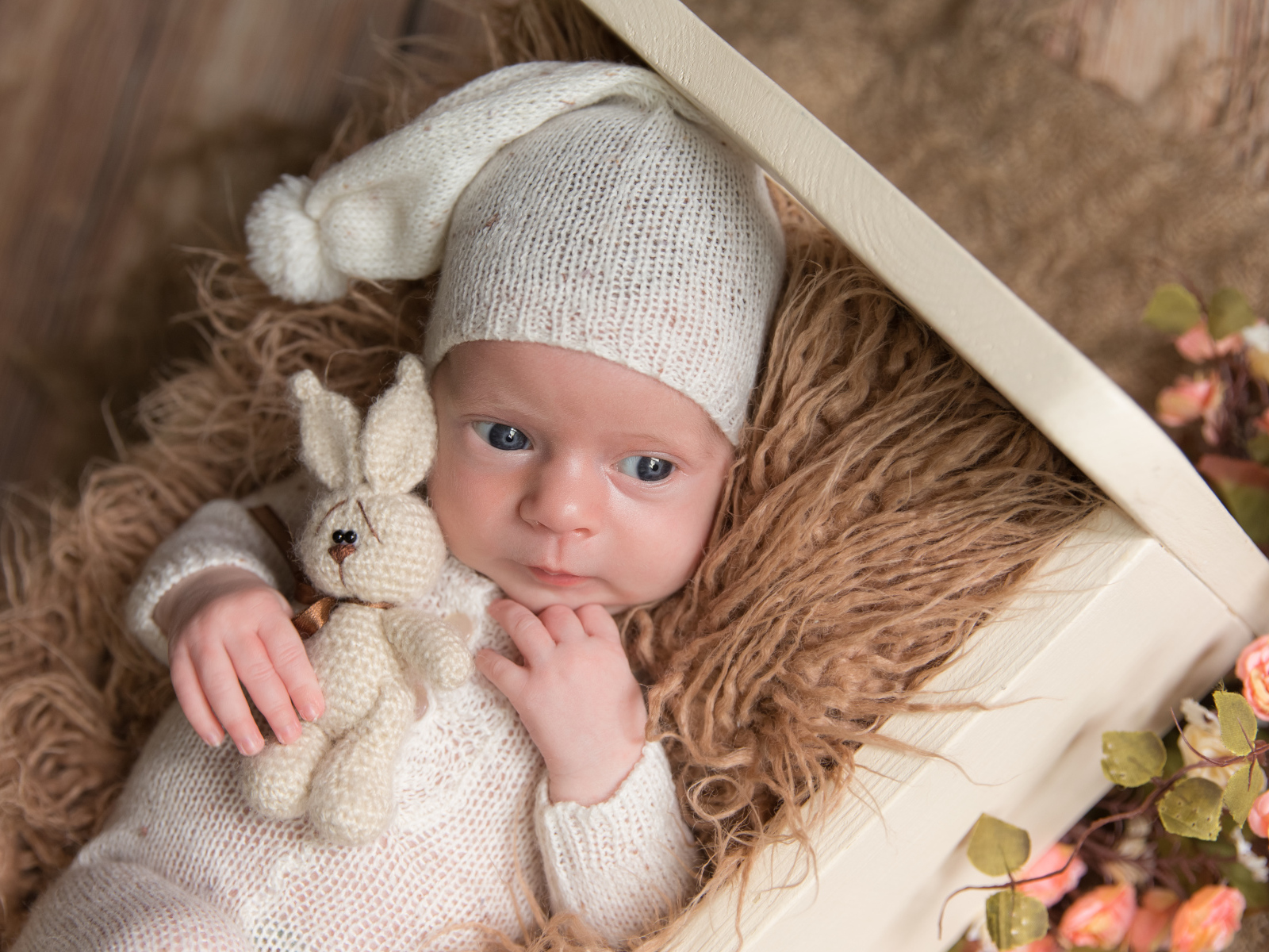 Маленький ребенок в вязанном костюме с зайчиком