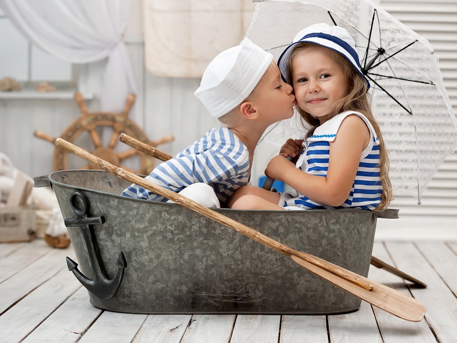 Маленькие мальчик и девочка сидят в железном корыте