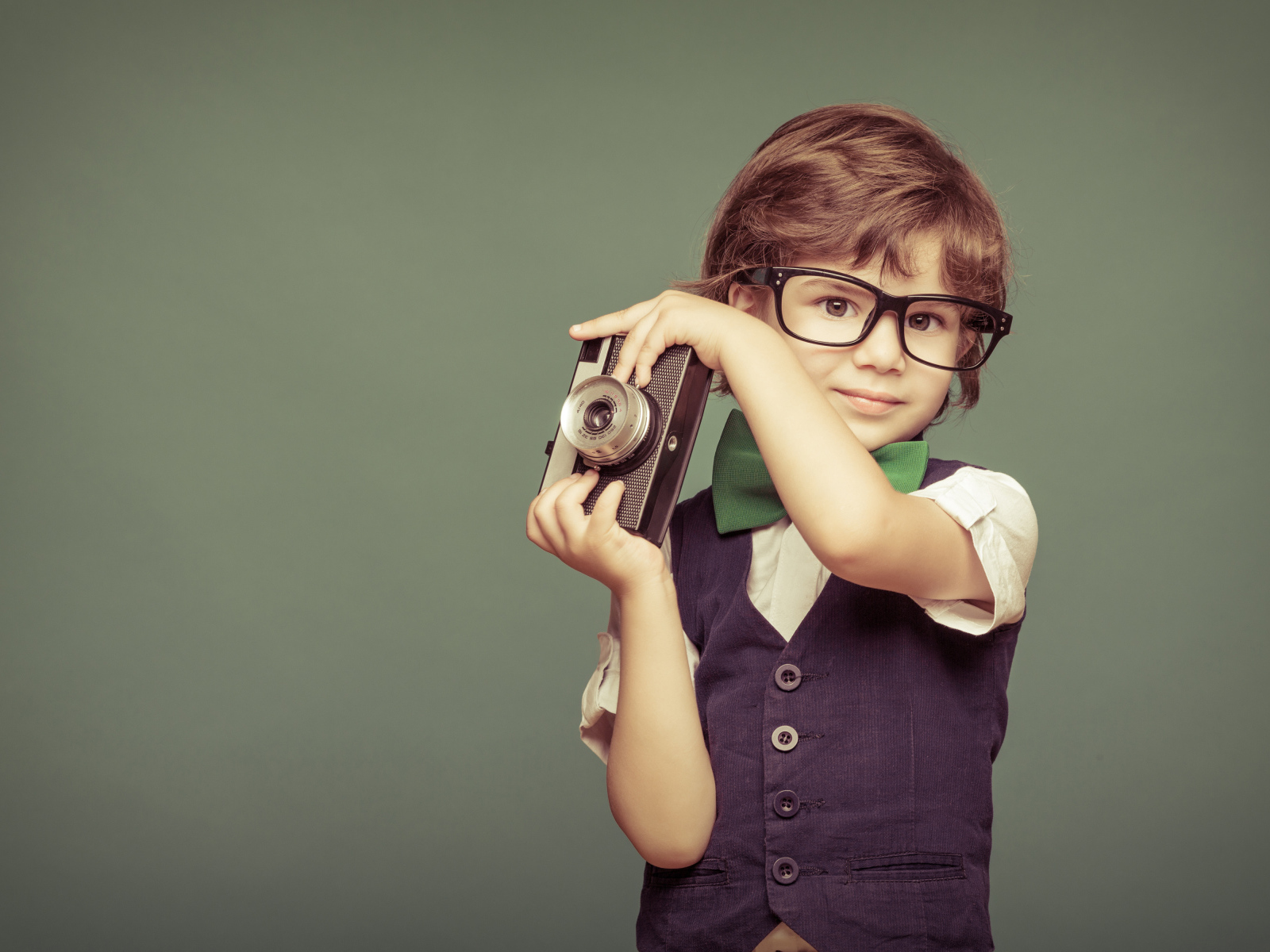 Маленький мальчик в очках с фотоаппаратом