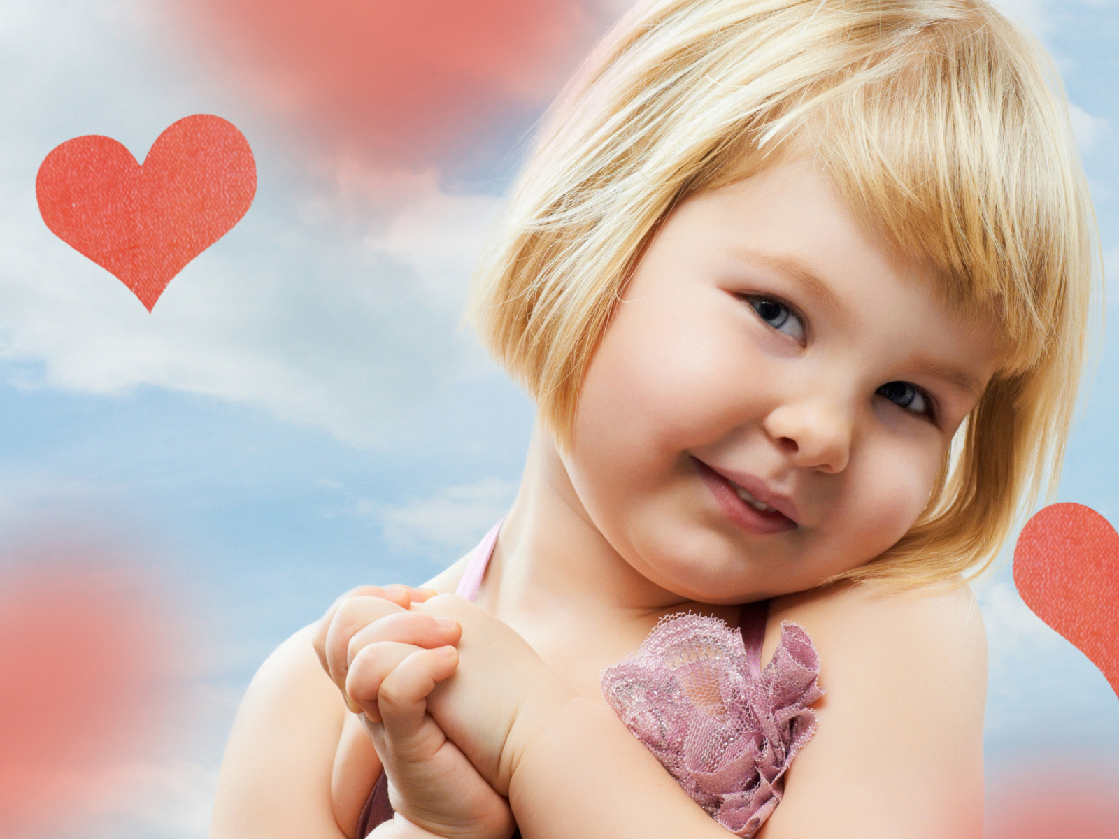 Маленькая милая девочка на фоне красных сердечек