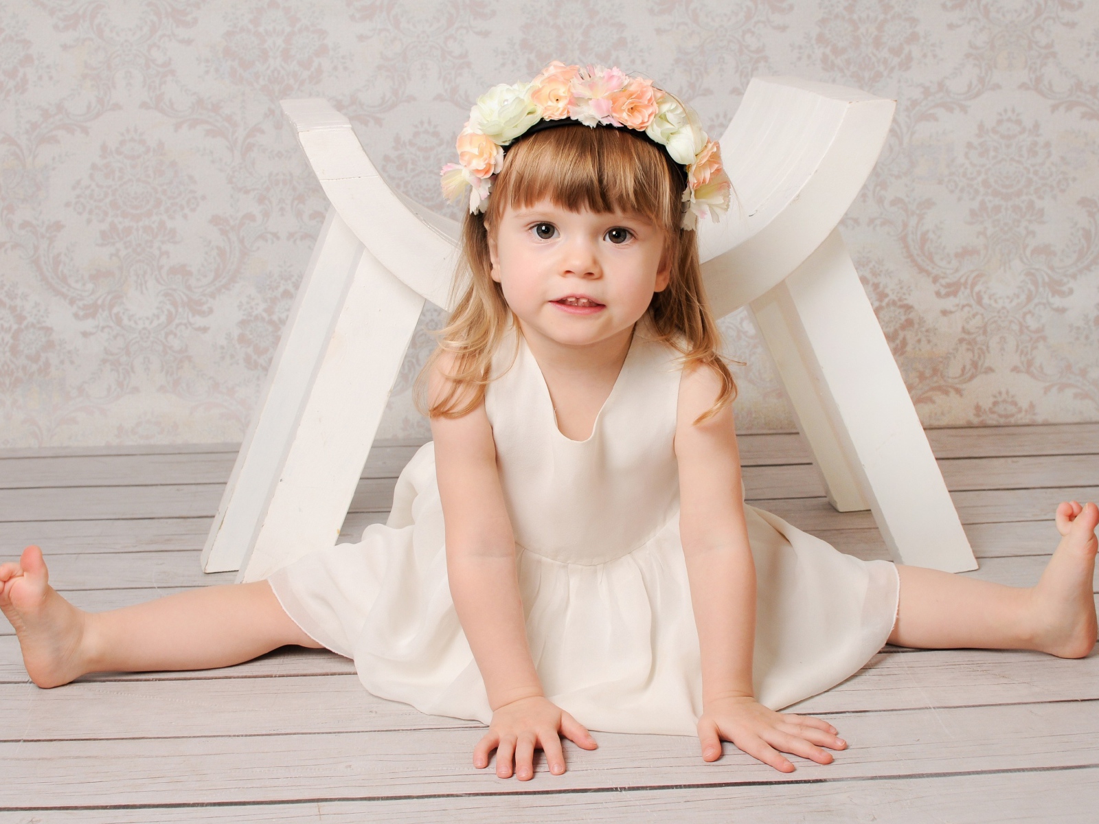 Маленькая девочка сидит на шпагате