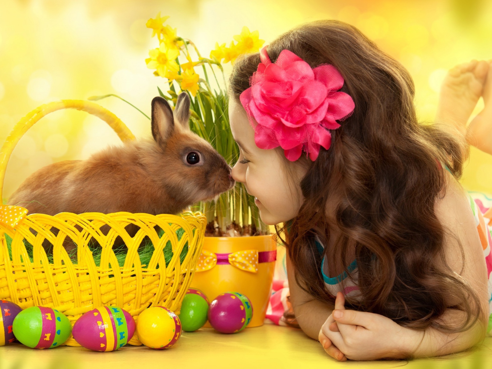 Маленькая девочка с кроликом в корзине на праздник Пасха