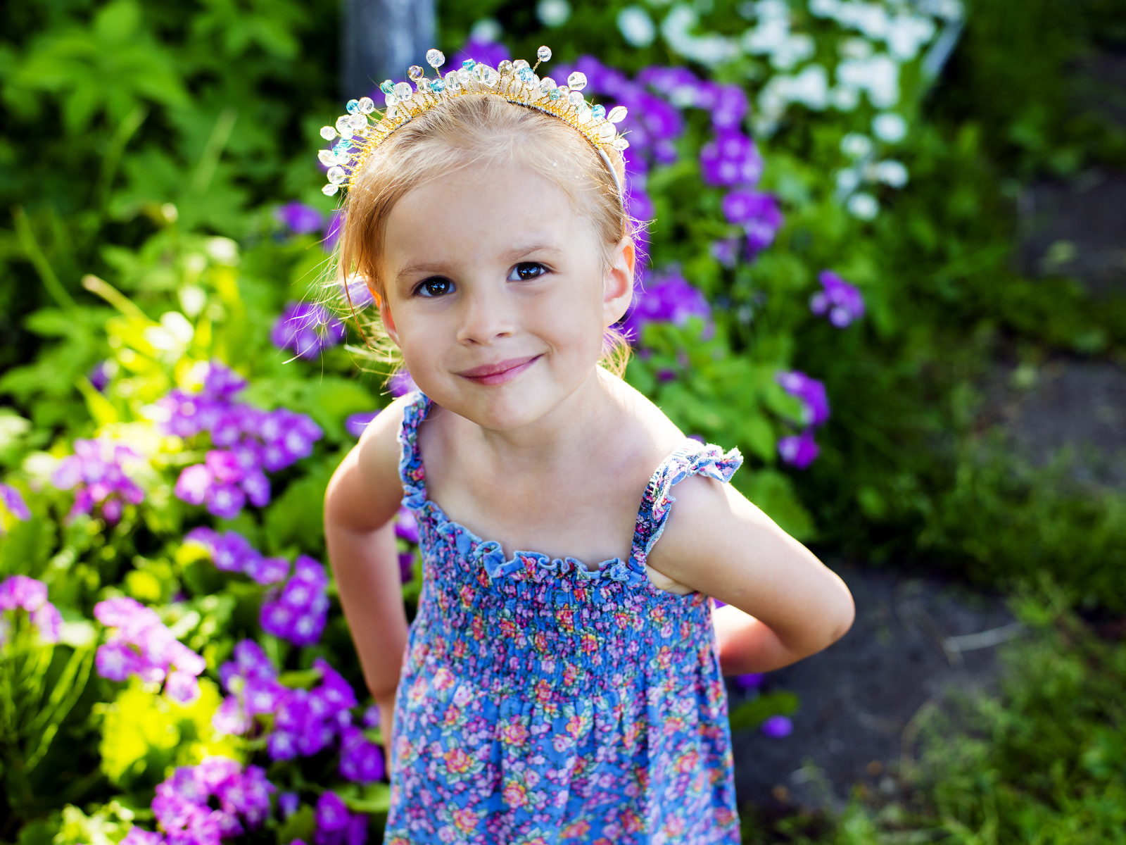 Маленькая улыбающаяся девочка с украшением в волосах 