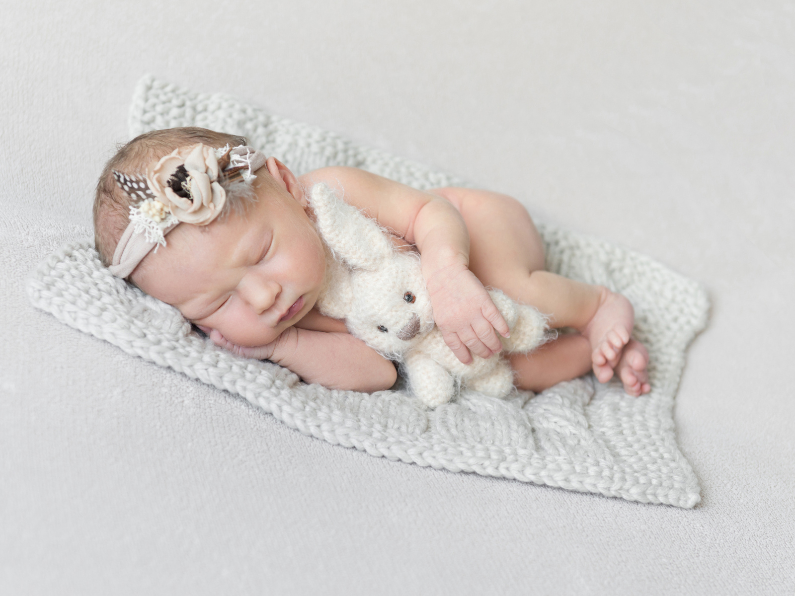 Спящий грудной ребенок с вязаной игрушкой
