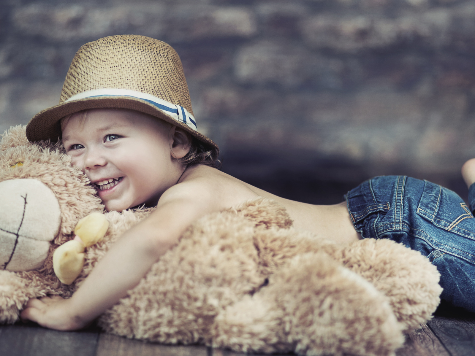 Улыбающийся мальчик обнимает игрушку