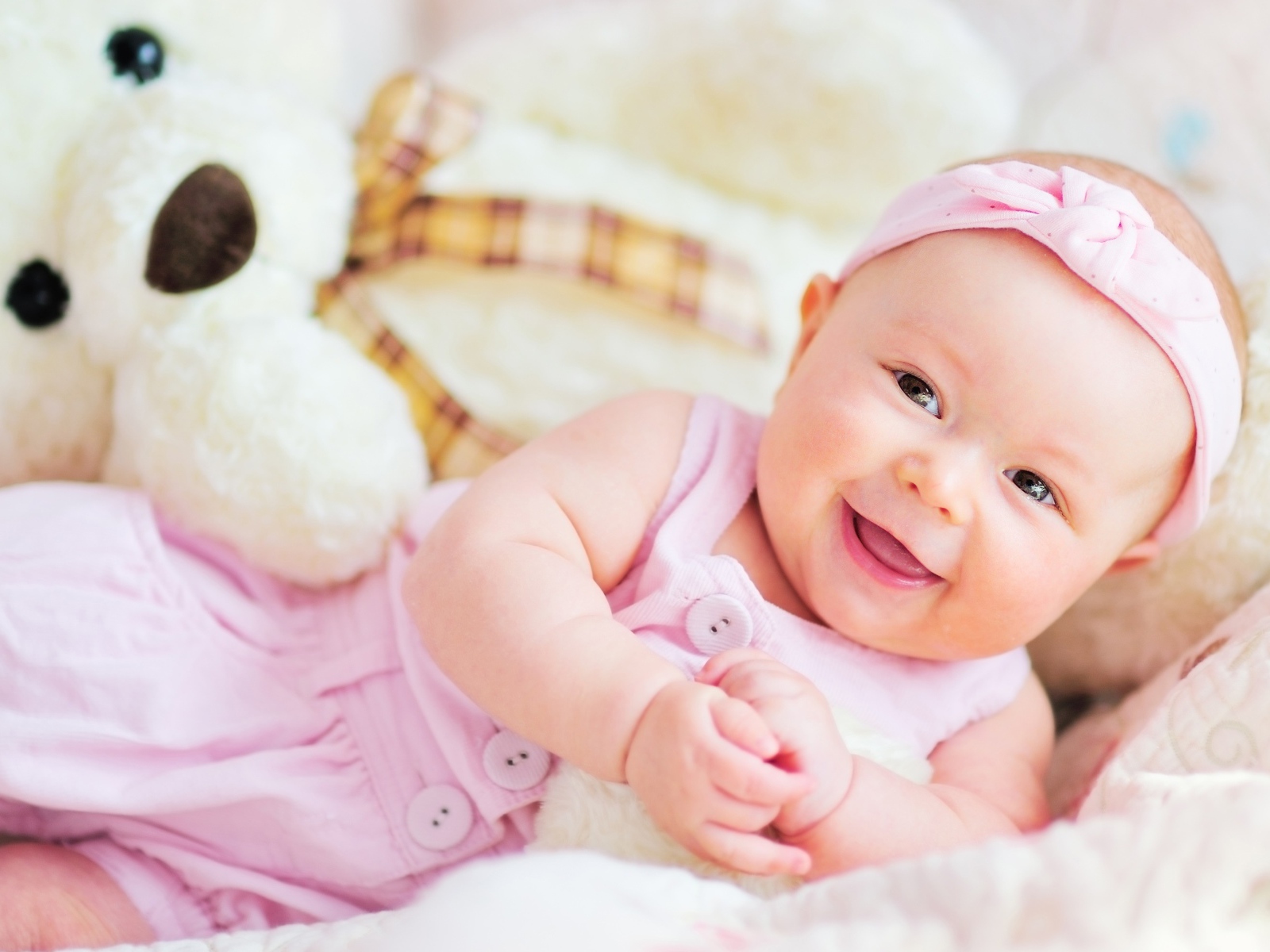 Улыбающаяся маленькая девочка с большим плюшевым медведем