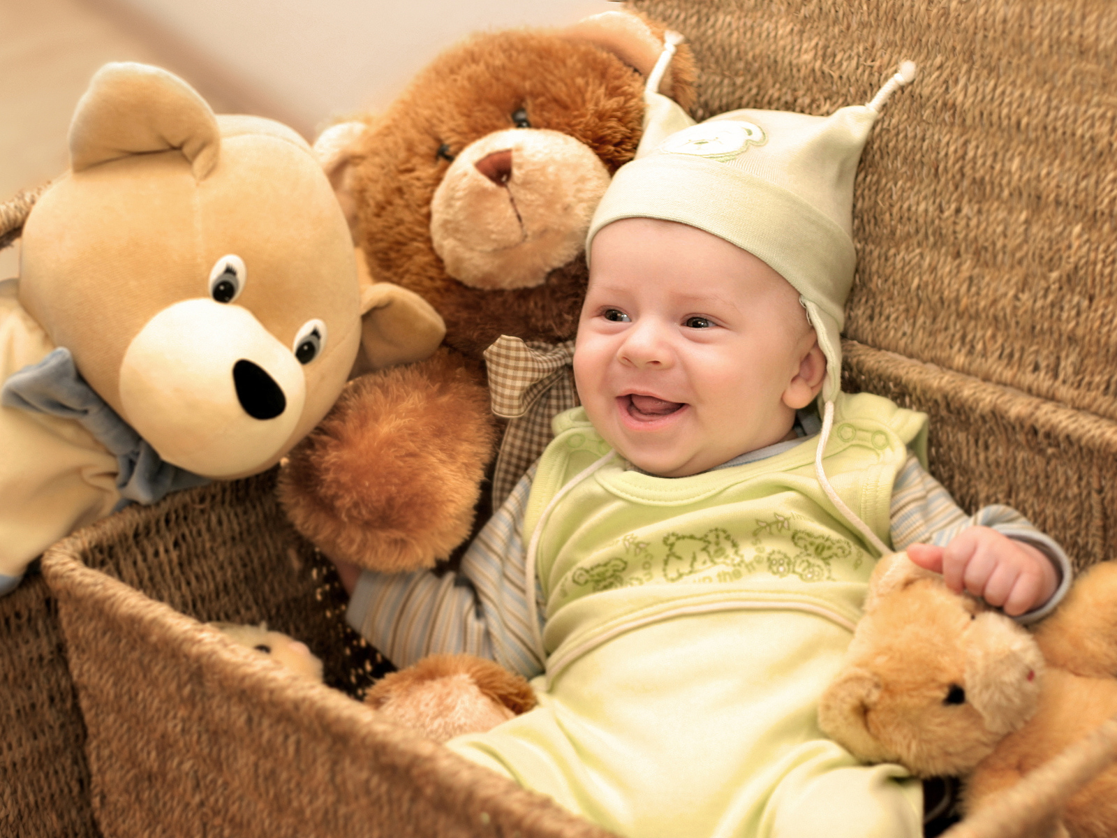 Грудной улыбающийся ребенок в корзине с игрушками