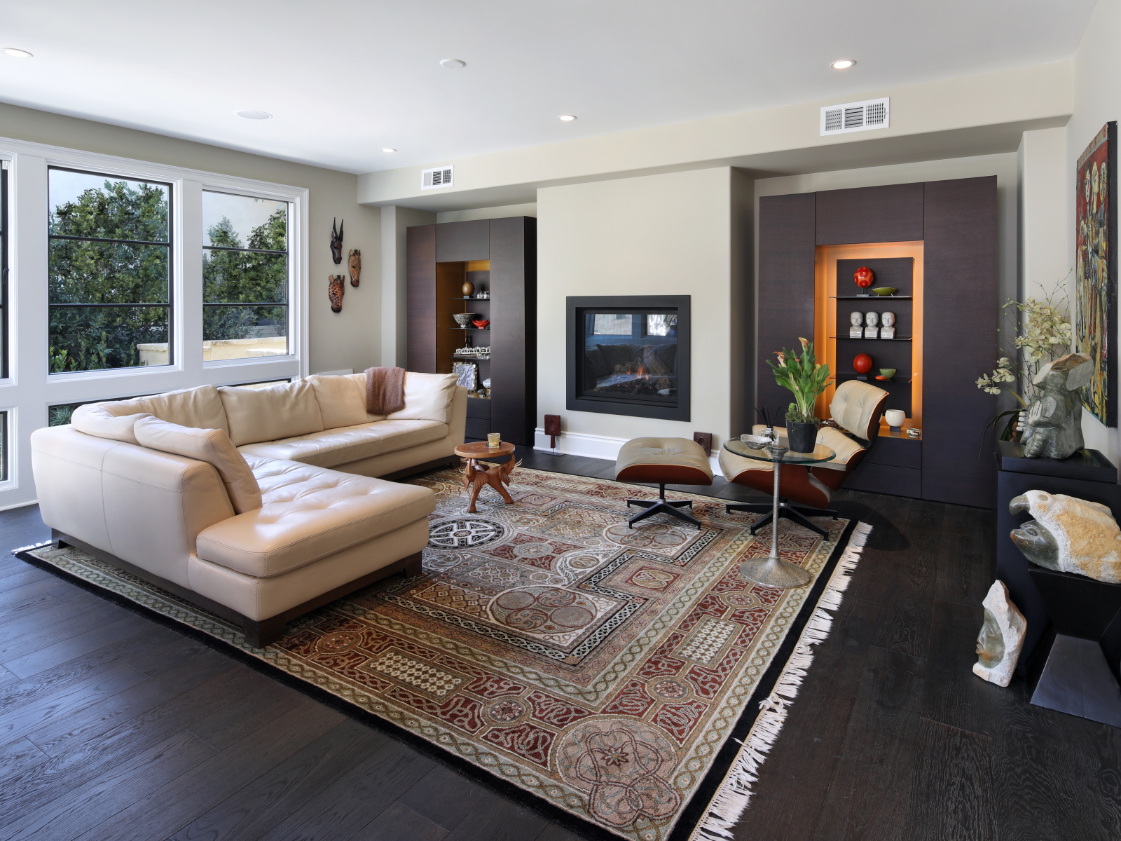 Стильная гостинная комната с белым кожаным диваном и ковром на полу