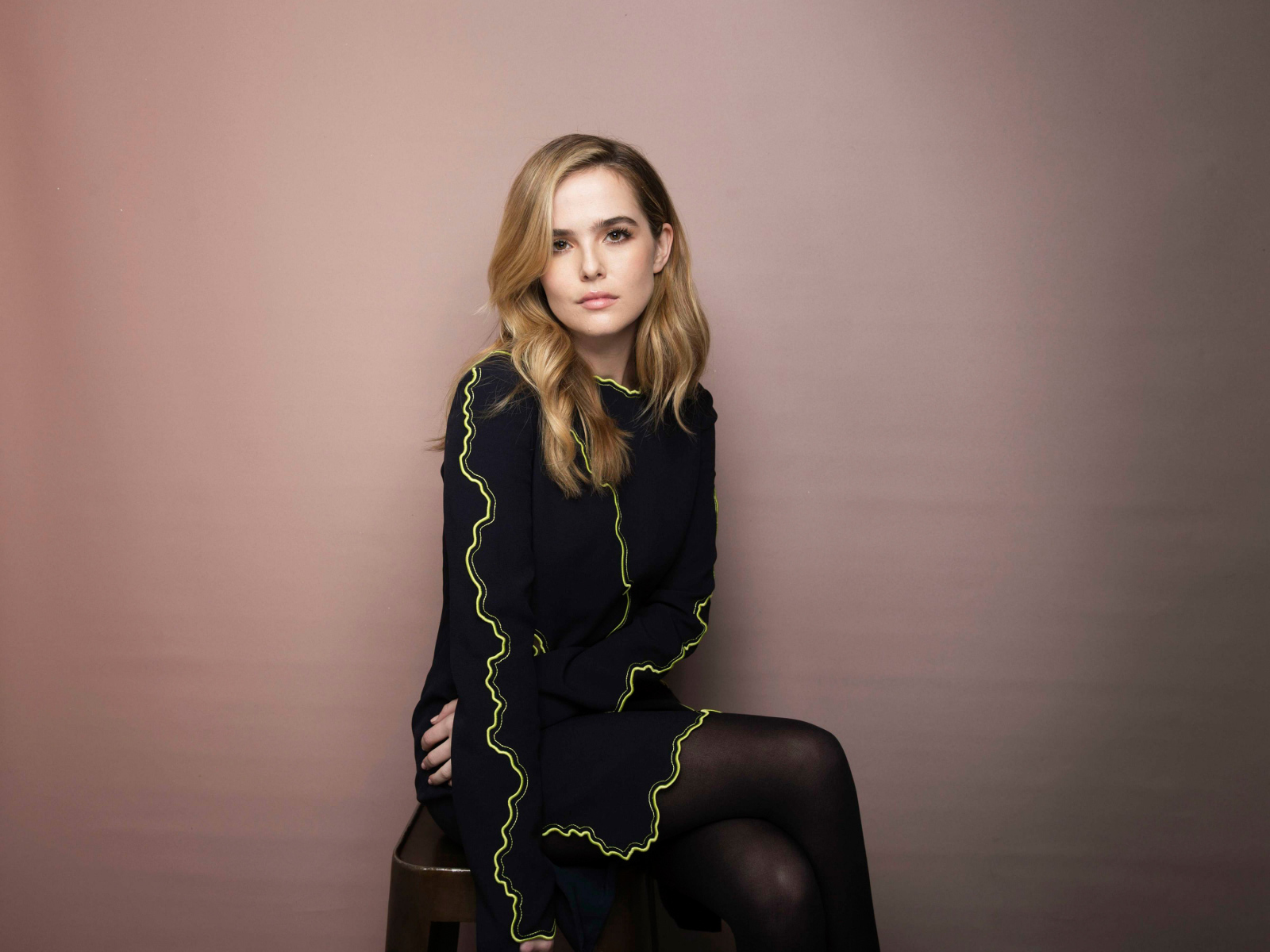 Актриса Зои Дойч в красивом платье сидит на стуле 