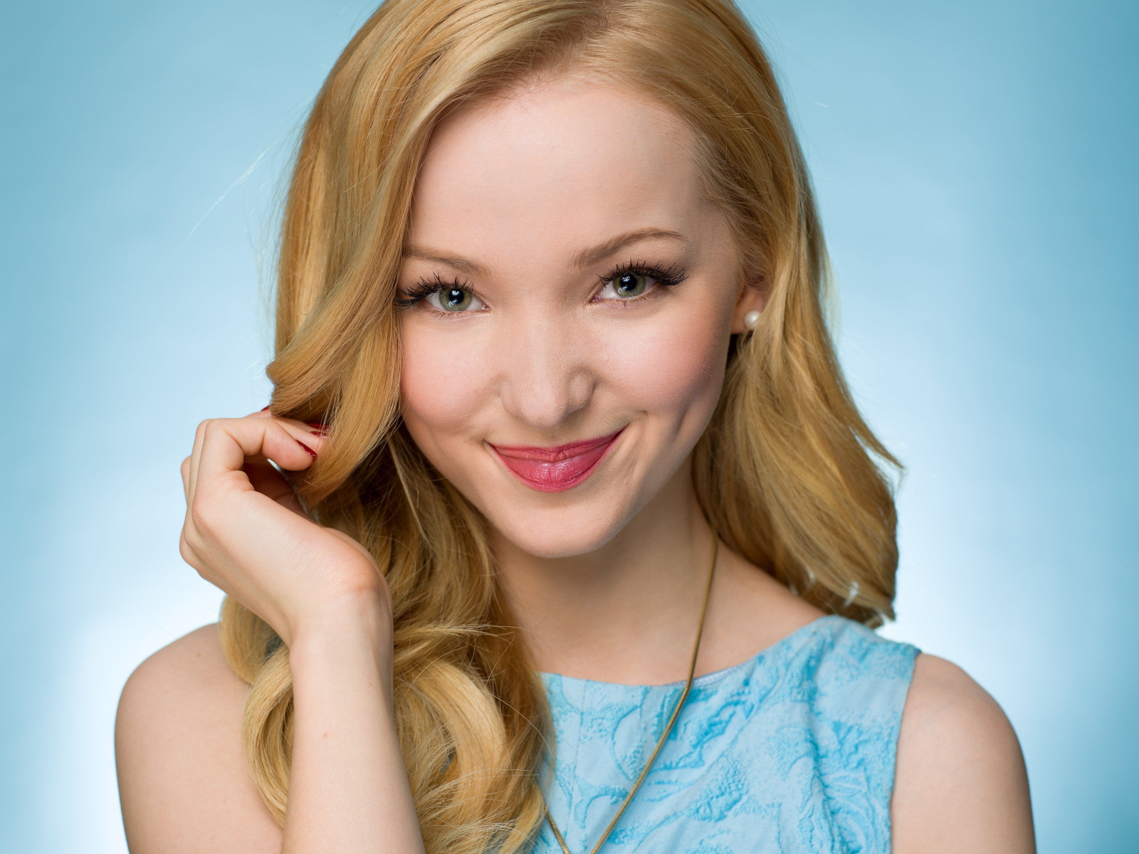 Улыбающаяся красивая девушка актриса Дав Кэмерон на голубом фоне