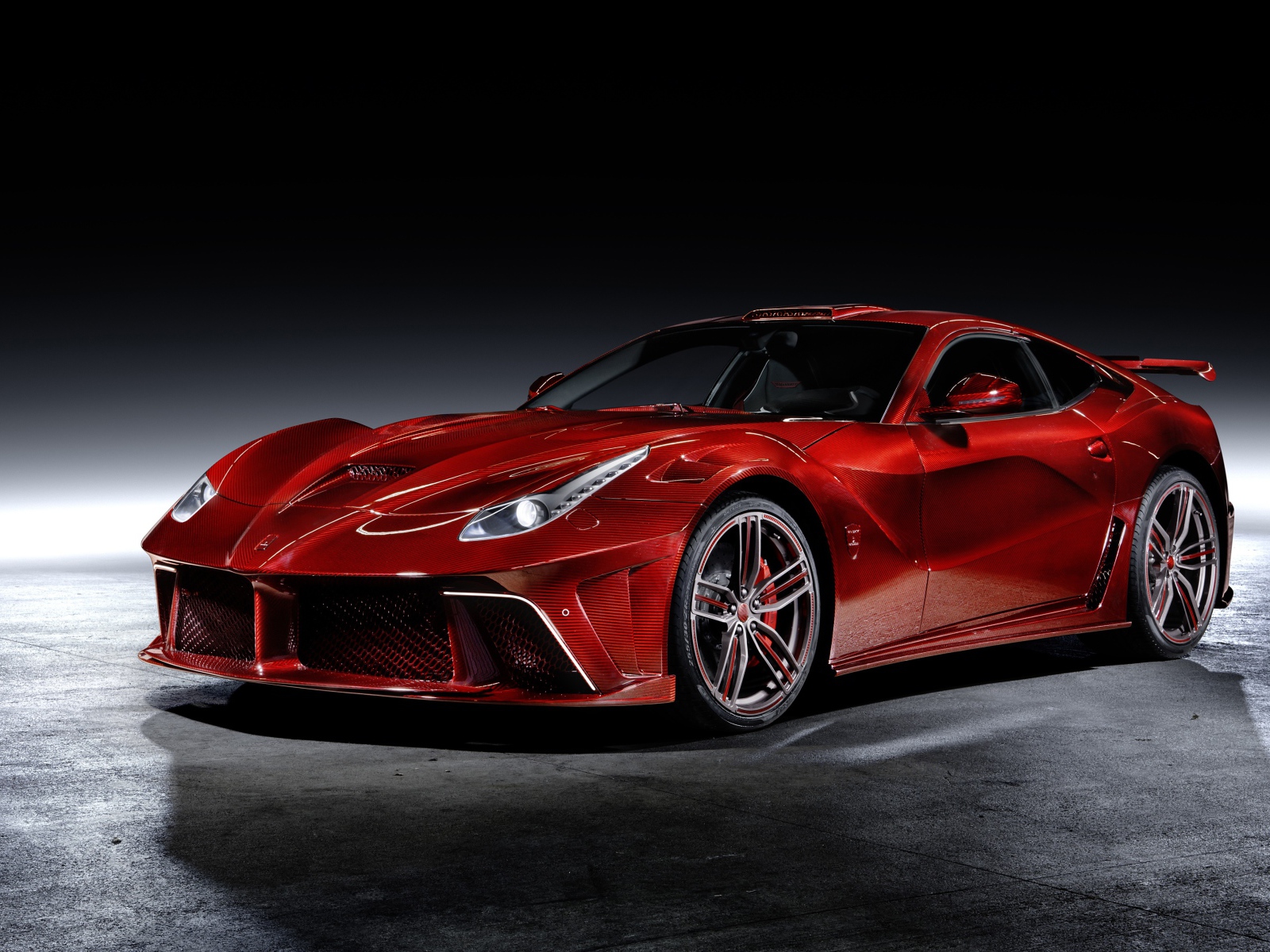 Красный автомобиль Mansory La Revoluzione на сером фоне