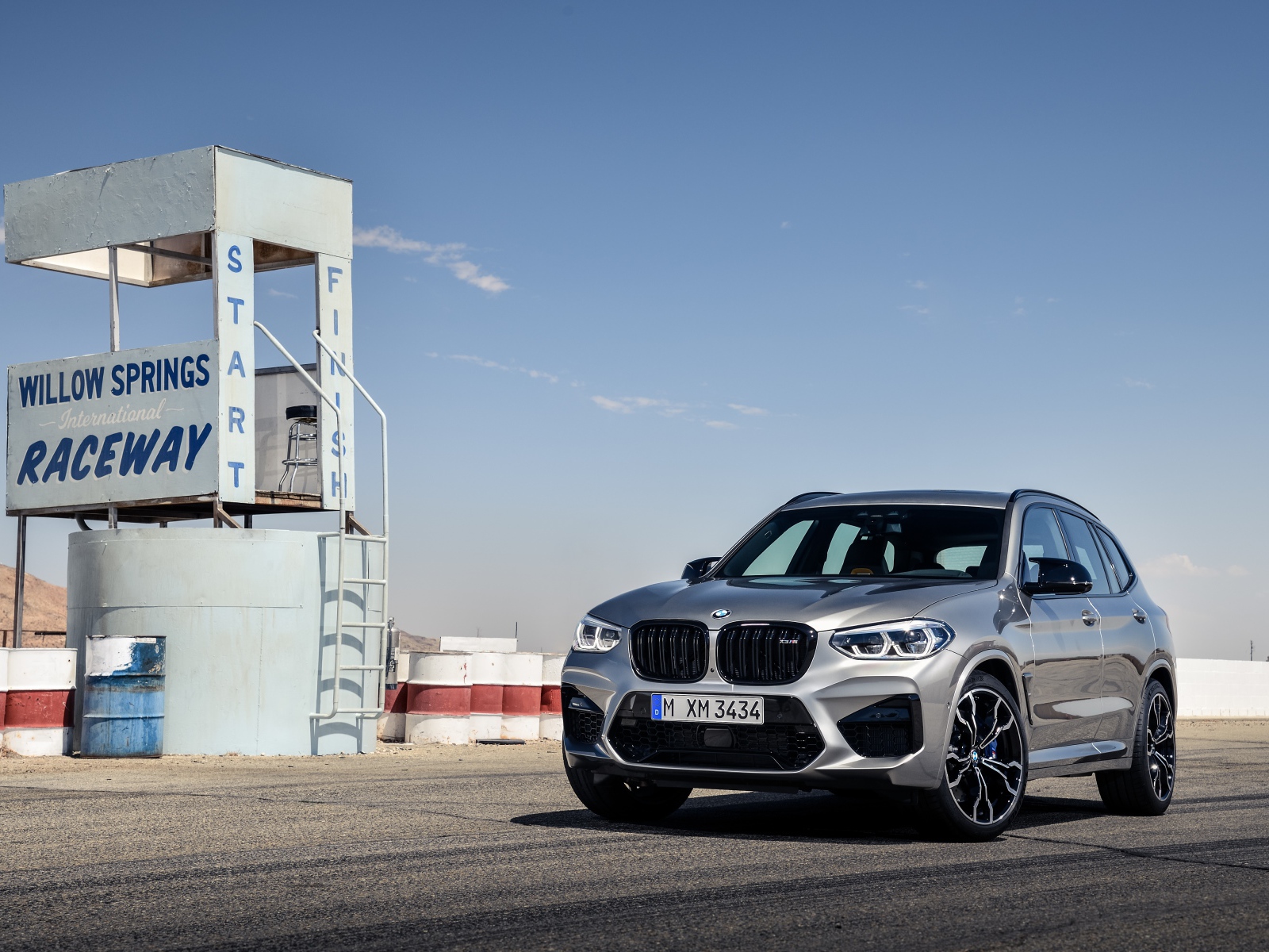 Серебристый автомобиль BMW X3 на асфальте