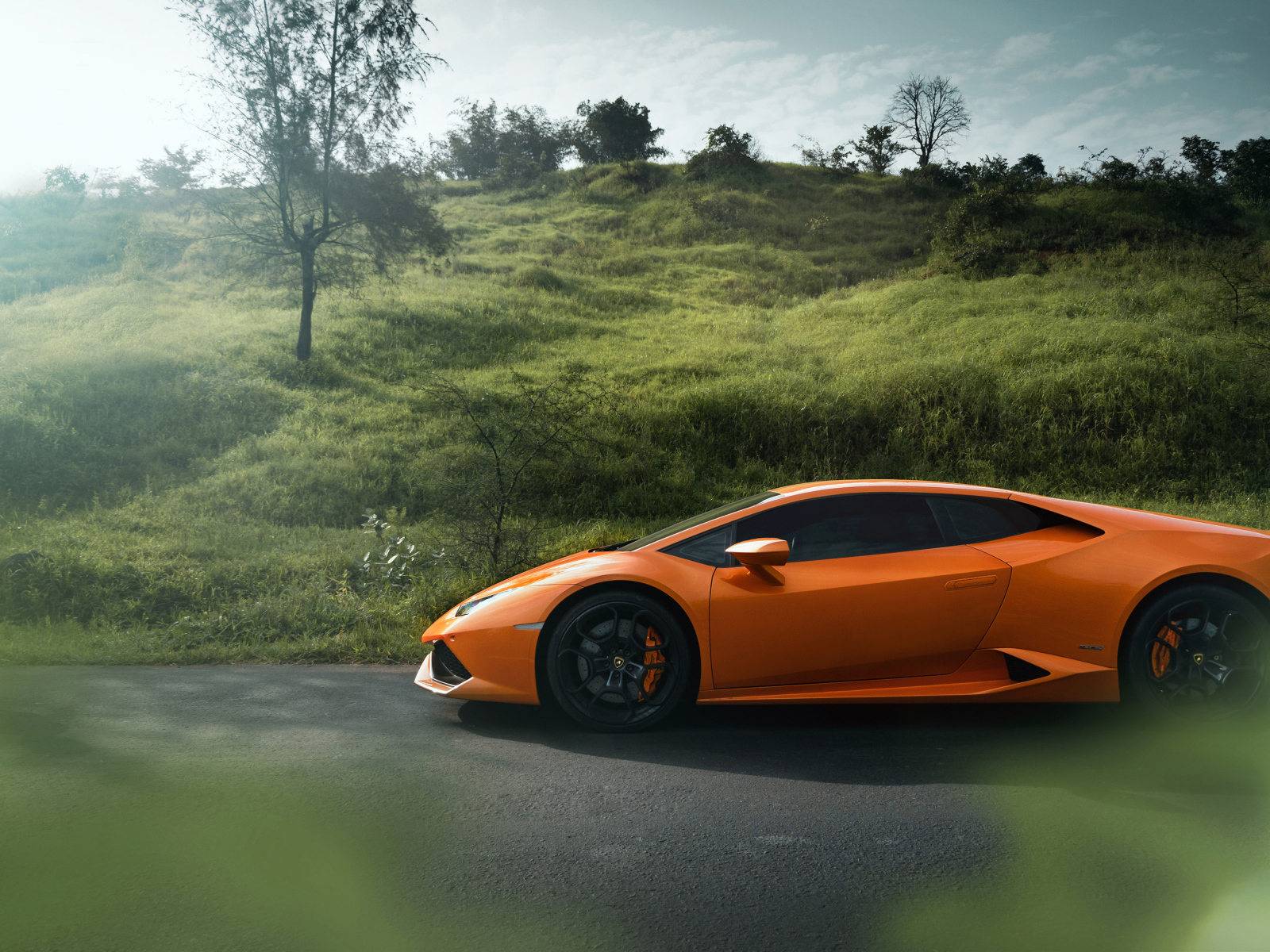 Оранжевый автомобиль Lamborghini Huracan 2019 вид сбоку