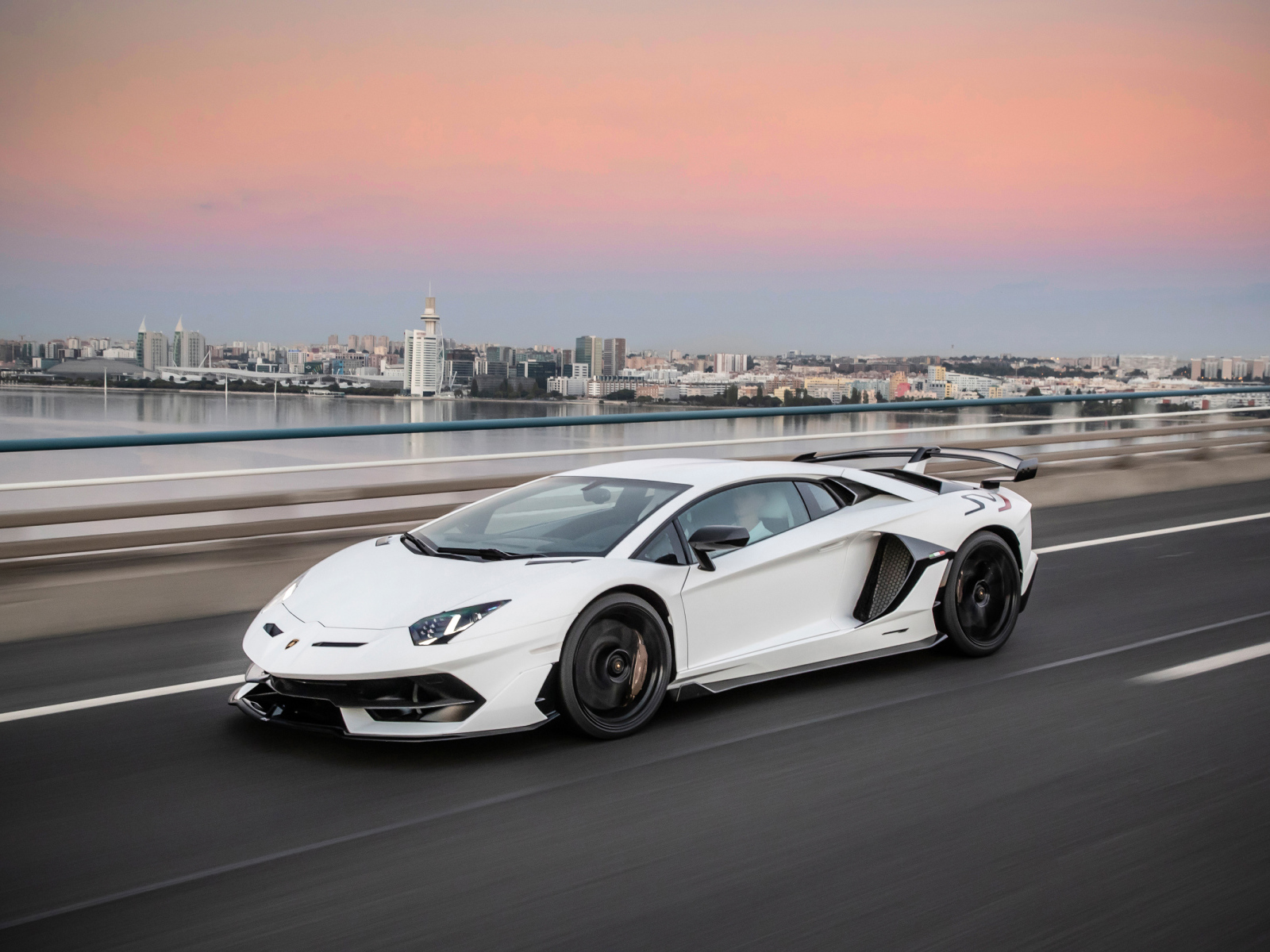 Белый автомобиль Lamborghini Aventador на трассе