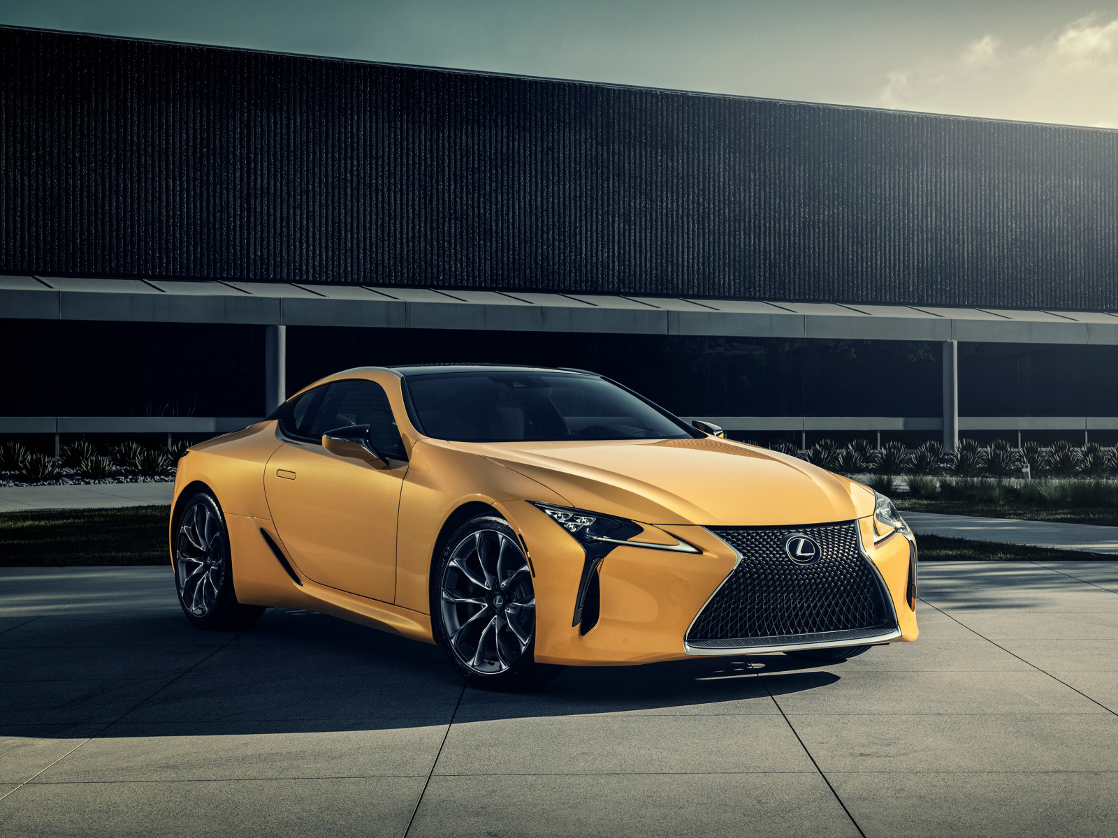 Желтый автомобиль Lexus LC 500 на фоне стены